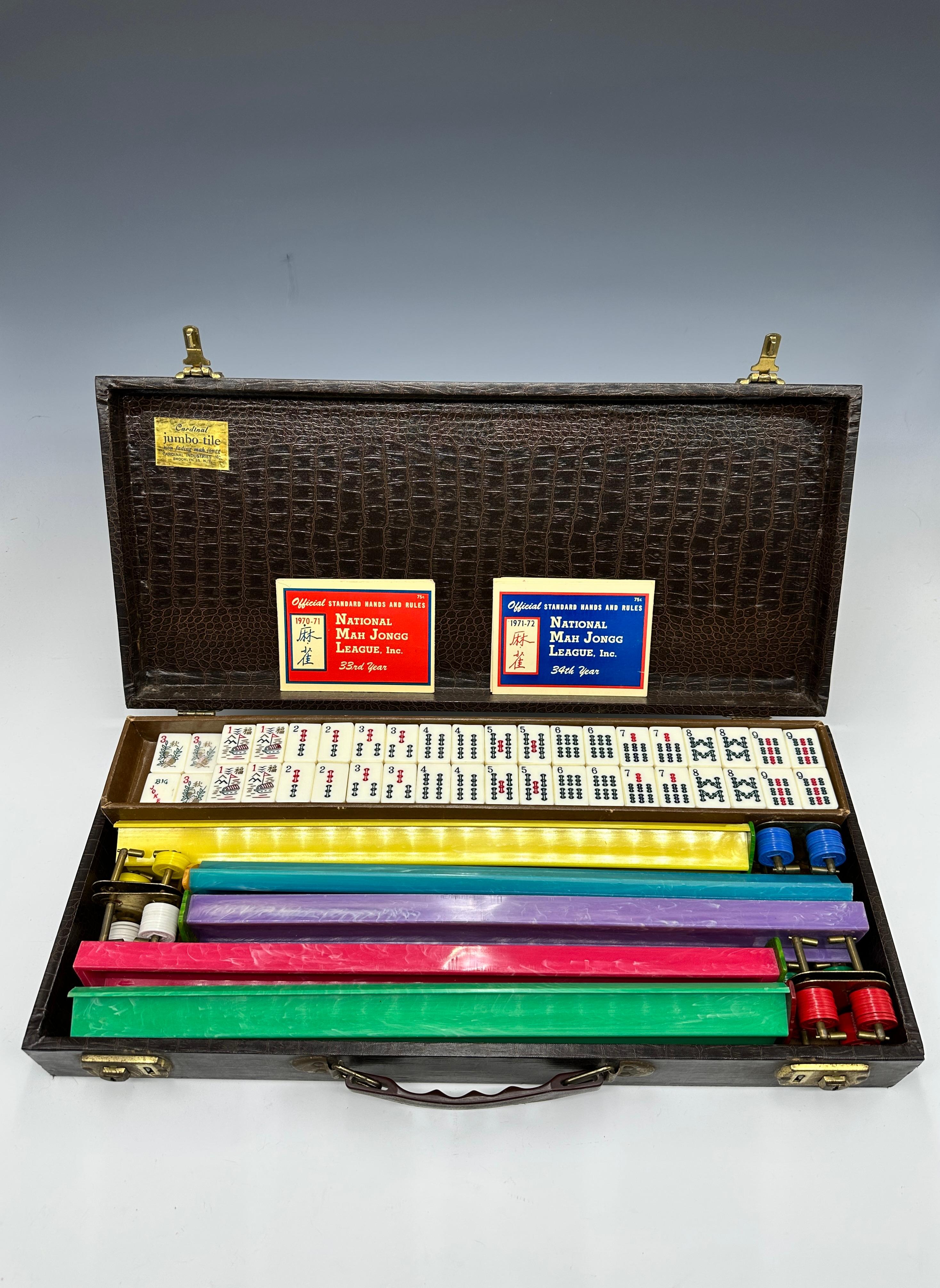 This vintage mid-century Cardinal Industries Mah-Jongg set from the 1960s is a true collector's piece that exemplifies craftsmanship and style. The deluxe set features 152 jumbo white Bakelite tiles, each beautifully preserved and tactilely