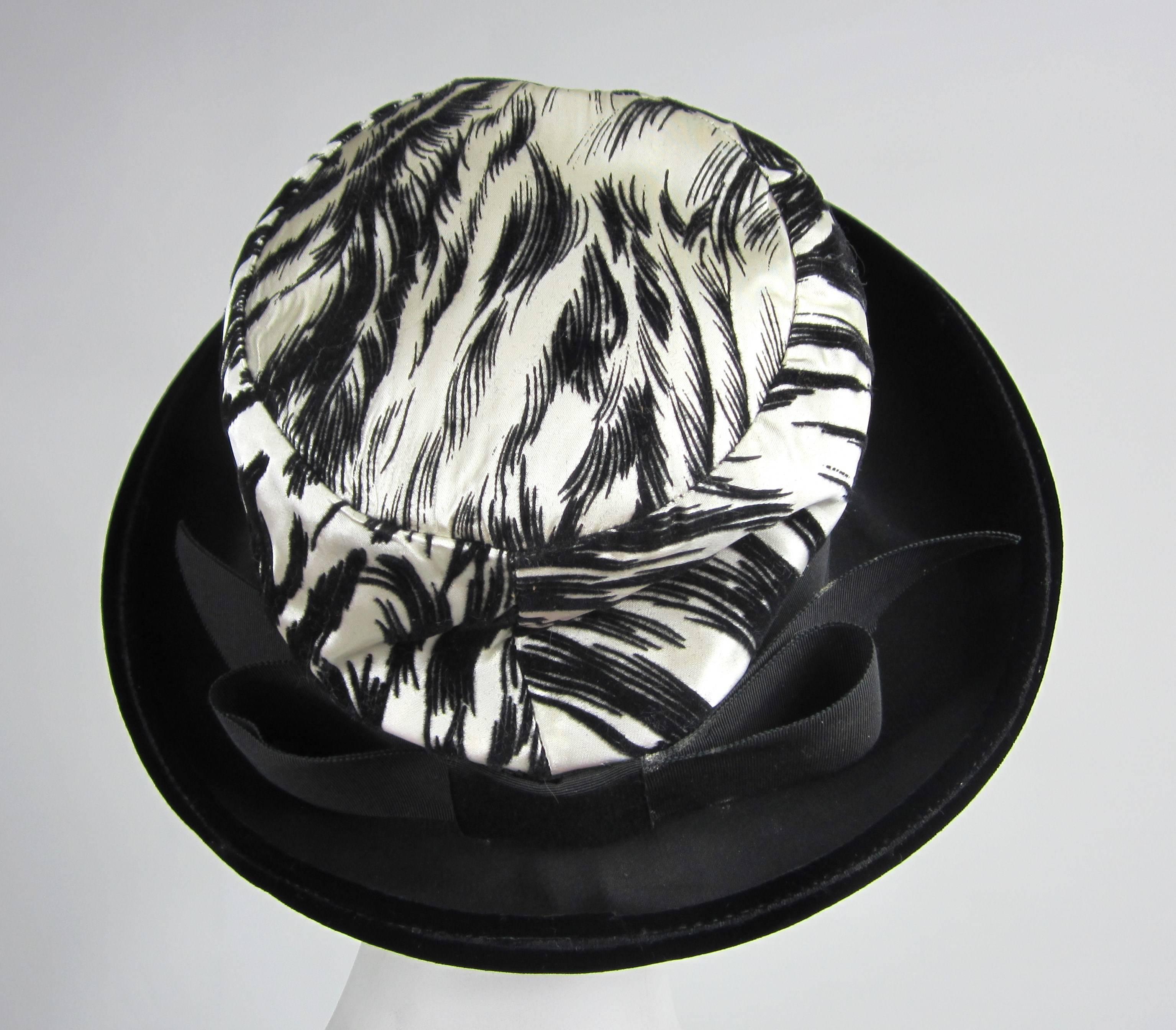 1960s Chesterfield Original Black and White Velvet Brimmed hat. Rolled brim. Large Bow at the back. The hat is approx 6-3/4 Small. The brim is 3.75 inches, sits up approx 6 inches.  Be sure to check our storefront for more fabulous pieces from our
