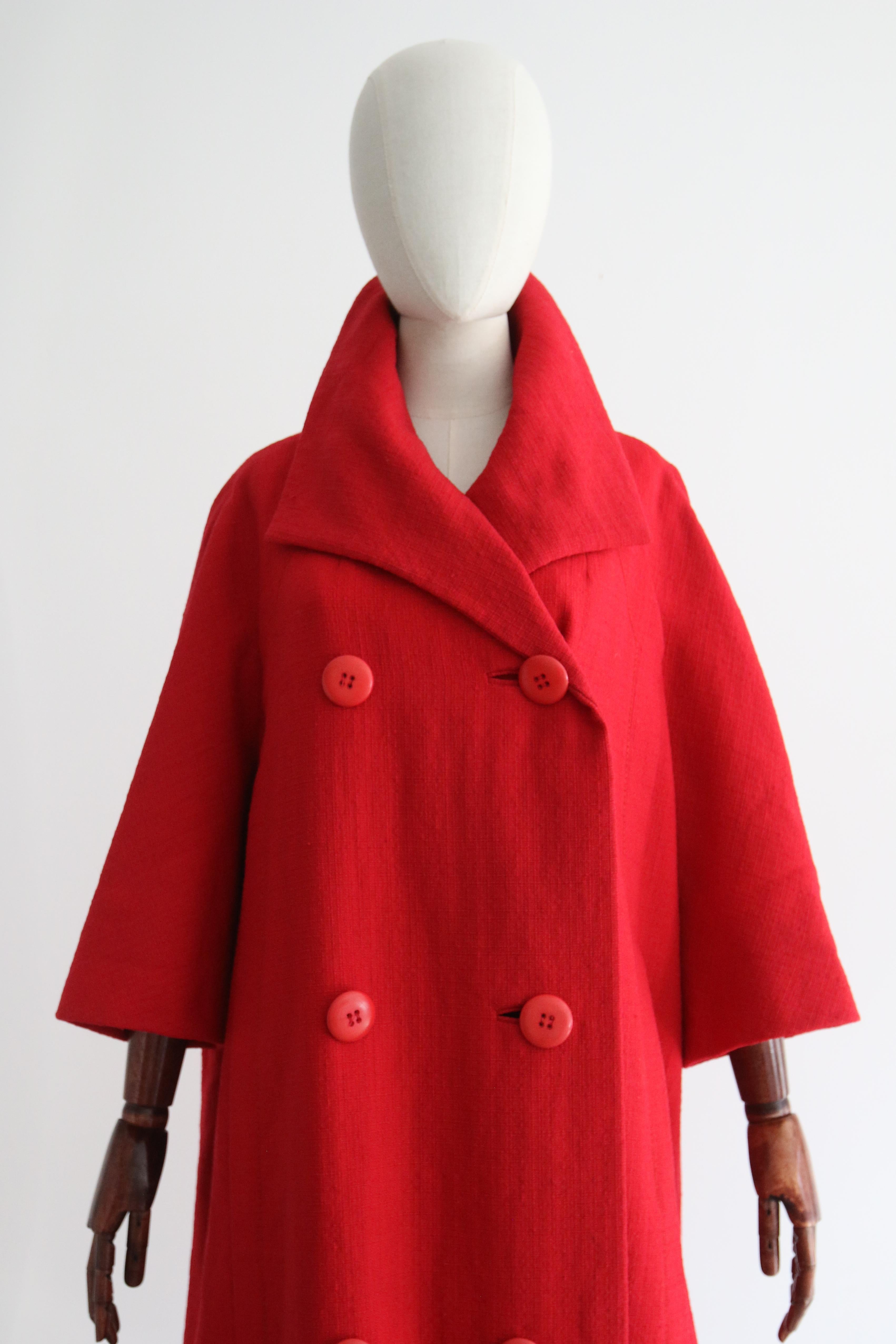 This rare 1960's Christian Dior mid-season red wool coat, is a rare piece to behold and the perfect statement piece for your transitional wardrobe. 

The V shaped neckline of the coat is framed by a wide pointed collar, which sets off the double