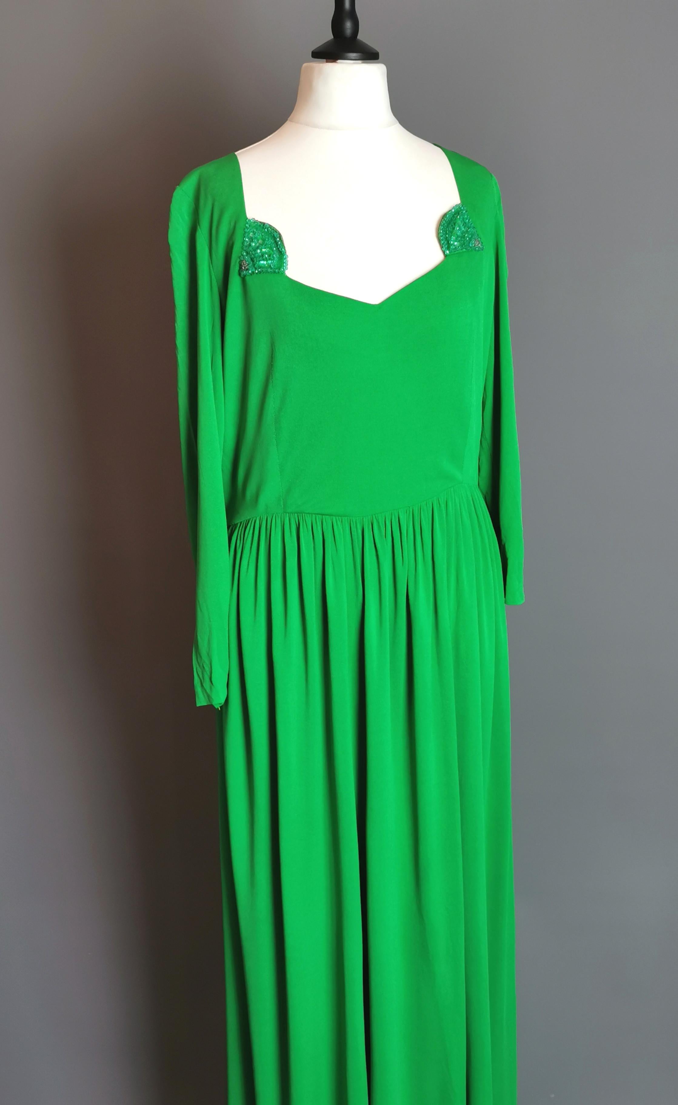 A gorgeous vintage late 1960s long length cocktail dress.

This is a stunning vintage dress, long sweeping ankle length skirts with a more fitted bodice and slim sleeves, the dress has a squared sweetheart style neckline.

Embellished at the corners