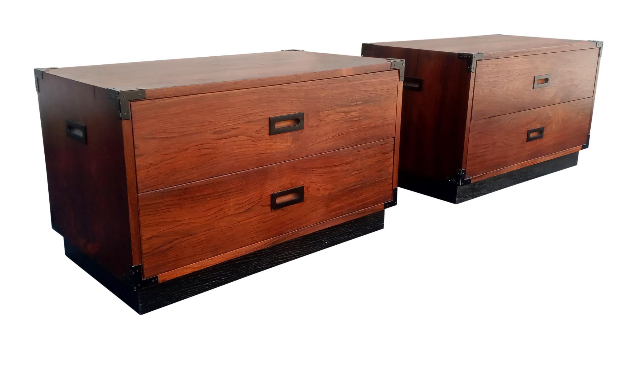 This is a fine well-made hefty pair of rosewood two-drawer nightstands, end-tables or lamp-tables. The grain is nicely figured with rich rosewood tones and a warm aged patina. The handles and corner mounts are enameled steel. The scale, proportions,
