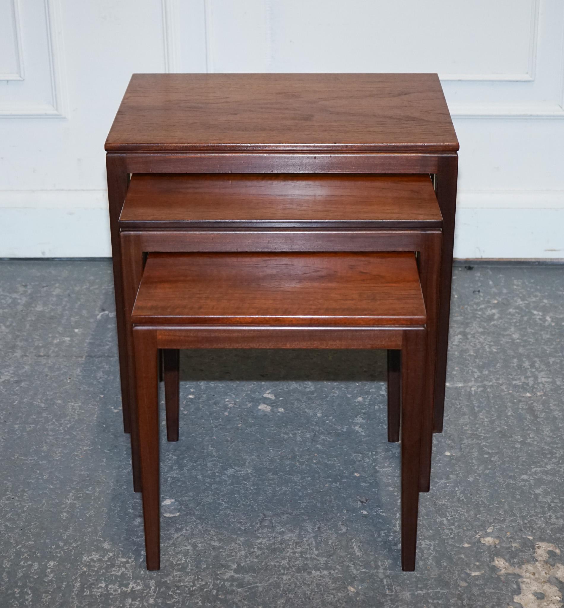 
Antiques of London



Elegant and functional set of three mid-century Danish nesting tables crafted in richly toned teak. Designed in the 1960s, this set embodies the minimalist sophistication of Scandinavian modernism, with clean lines, slim