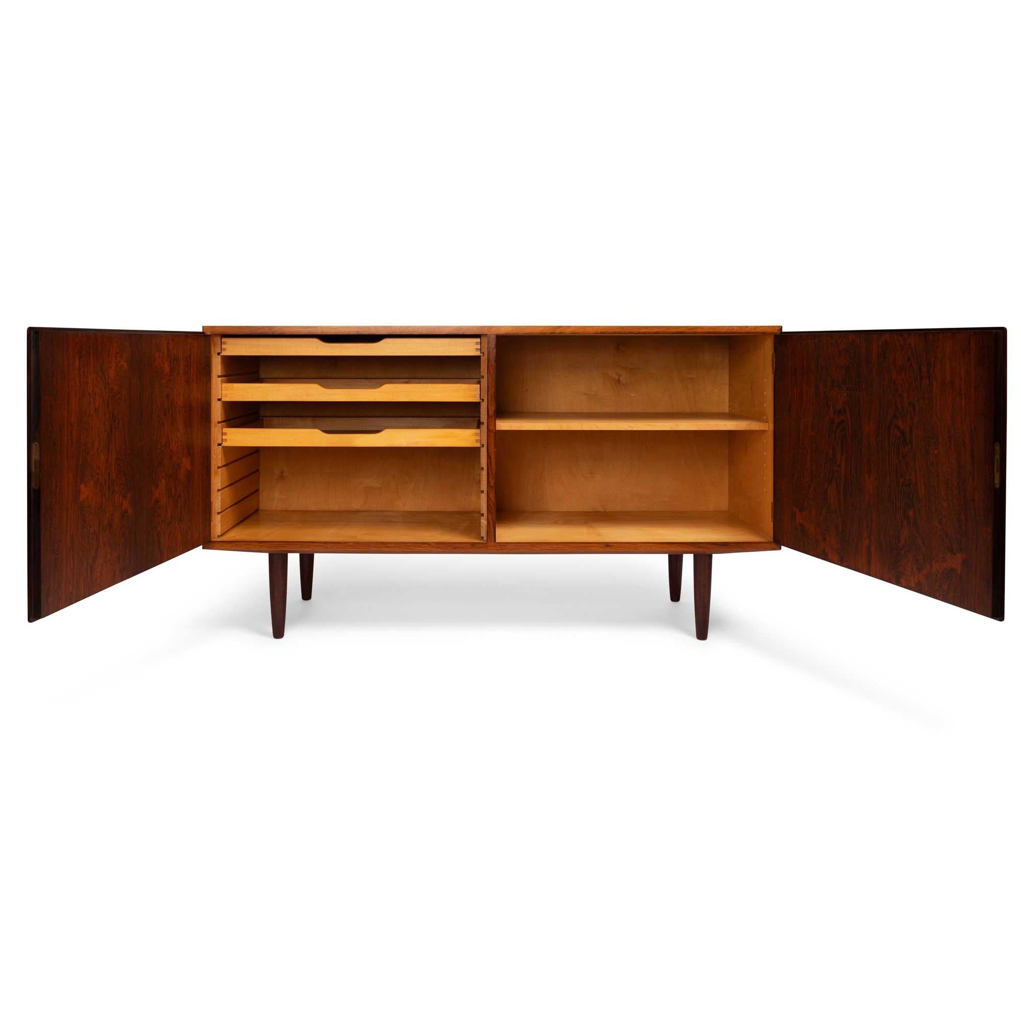 This beautiful 1960s vintage Danish Mid-Century credenza/sideboard has a stunning rosewood grain. This credenza features two key-locking compartments with plenty of storage space. The left compartment has three adjustable pull-out drawers for