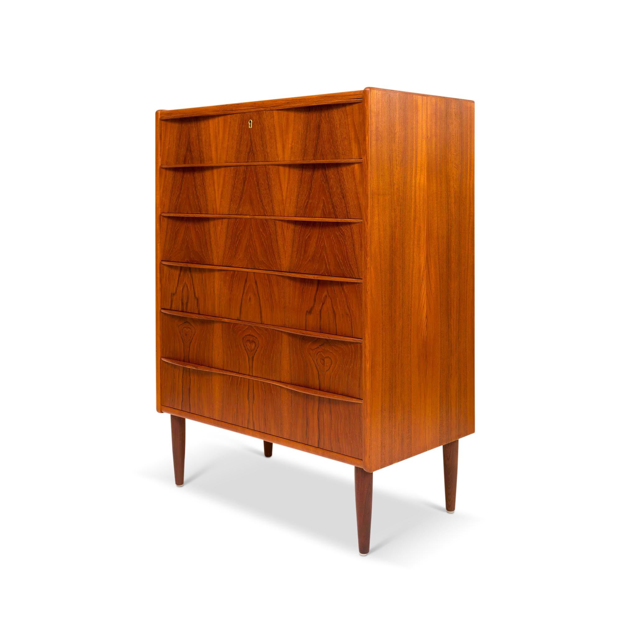 Crafted with meticulous artistry in 1960s Denmark, this stunning modern Danish mid-century Teak Tallboy stands as a testament to unparalleled craftsmanship. Its allure lies in the exquisite teak wood-grain detailing that adorns the tallboy dresser,