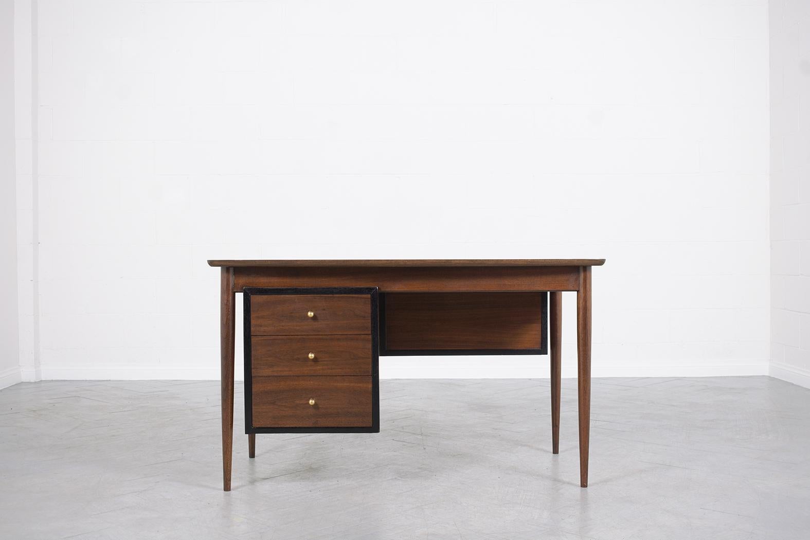 Embrace the enduring allure of Danish design with this splendid mid-century executive desk, meticulously handcrafted from select walnut wood. Freshly restored and refinished by our seasoned craftsmen, this vintage gem showcases a deep walnut hue