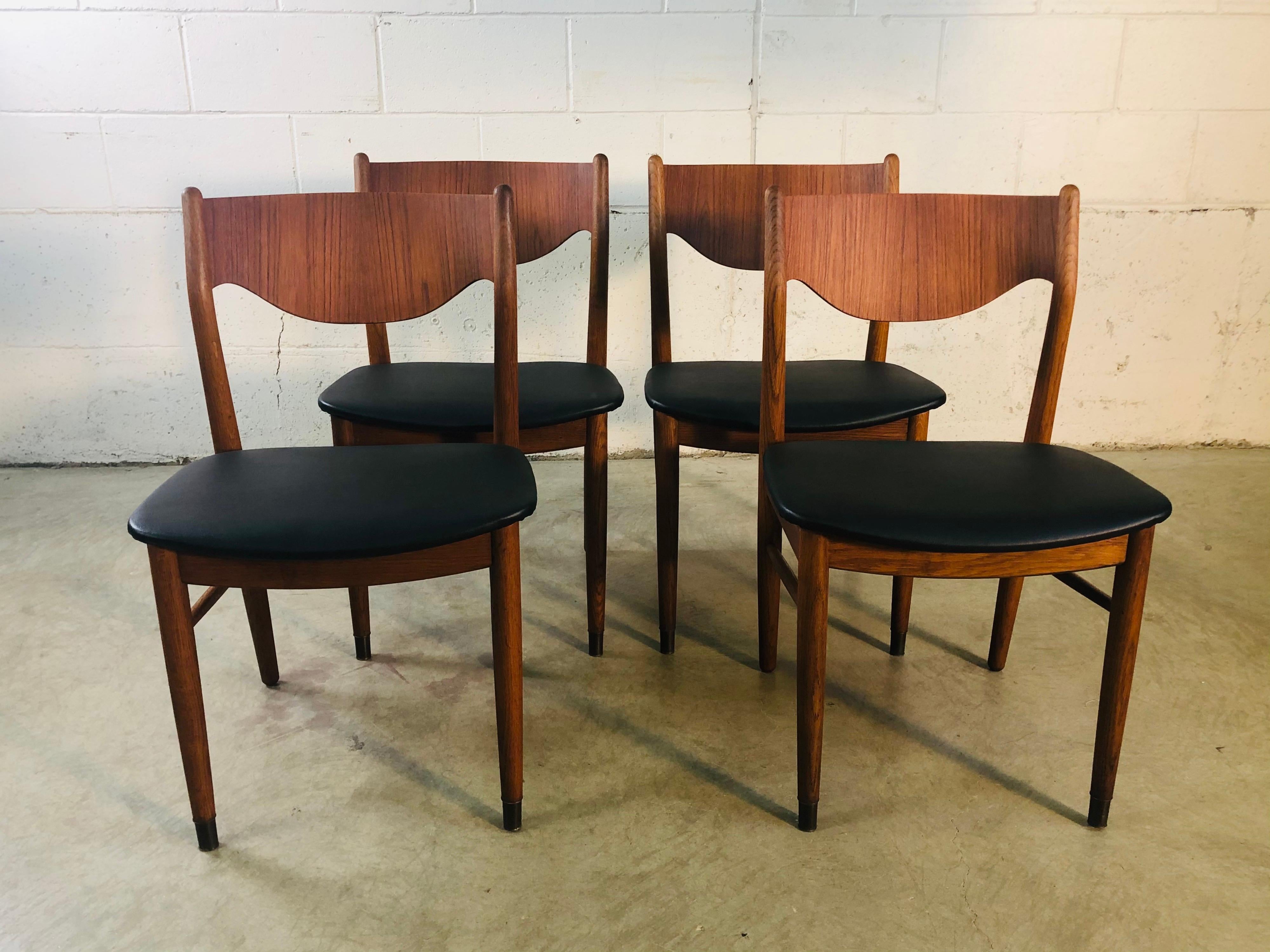 Vintage 1960s set of 4 Danish teak and beech wood rounded back dining room chairs. The chairs have brass accents on the feet. Great rounded backs and new Naugahyde seats. Newly refinished condition. No marks.