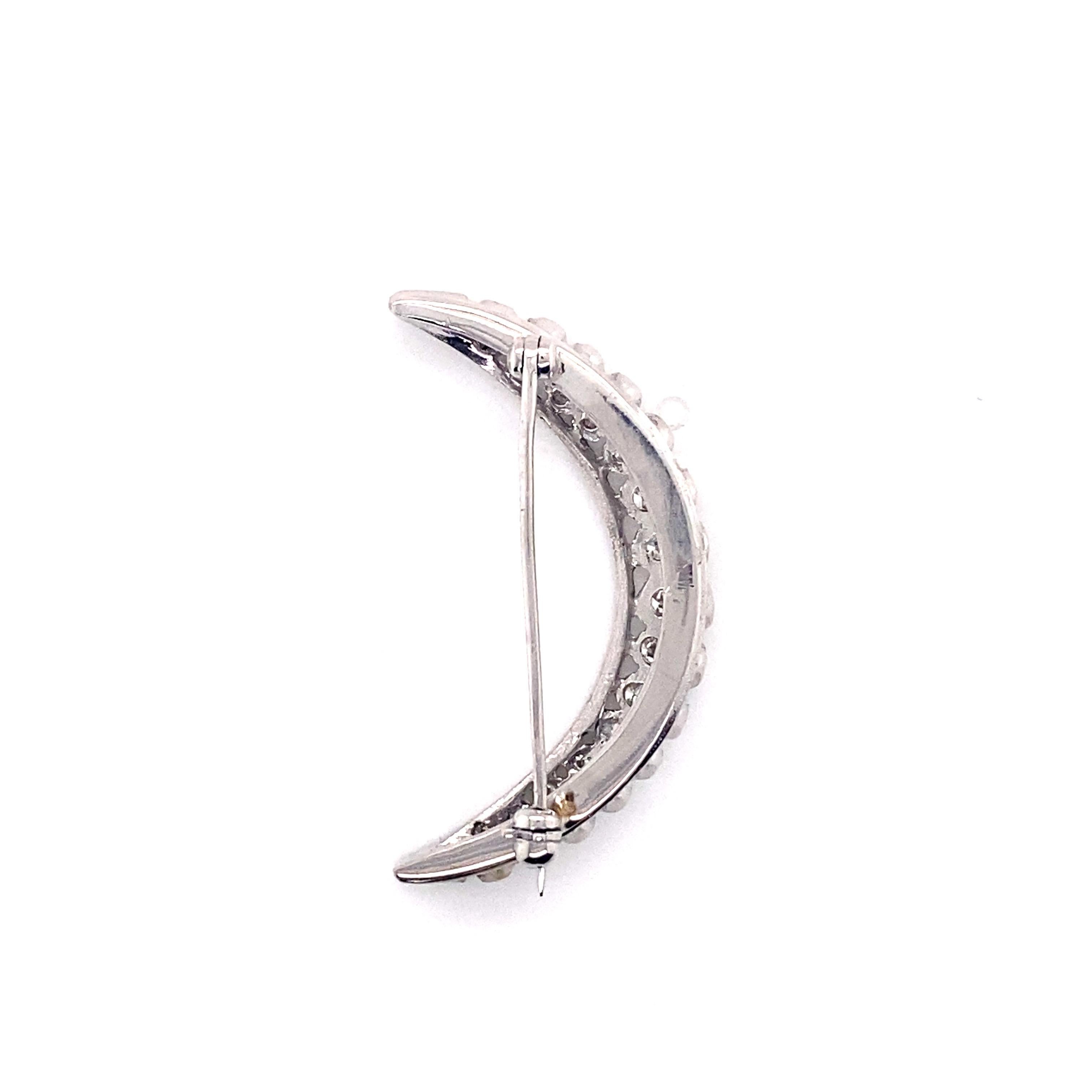 A celestial delight, this vintage crescent moon pin from the 1960s exudes timeless beauty. Rendered in luxurious 14K white gold, the dimensional design features a crescent moon silhouette shimmering with 15 round brilliant diamonds. The diamonds