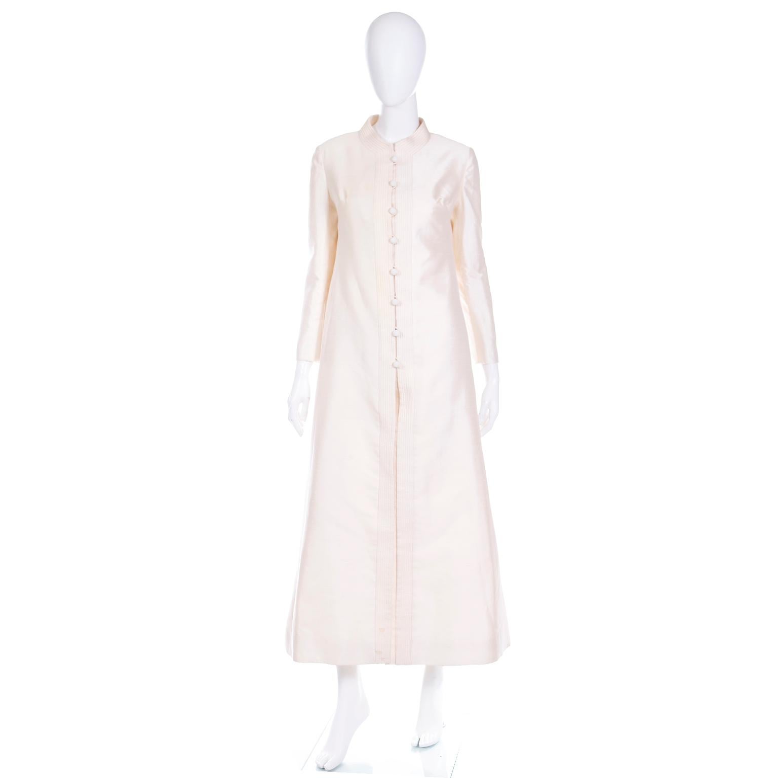 This is a long vintage Dynasty late 1960's or early 1970's creamy ivory silk evening coat. We love coats like these because they can be worn so effortlessly with things already found in a modern wardrobe. This would also make a beautiful coat for a