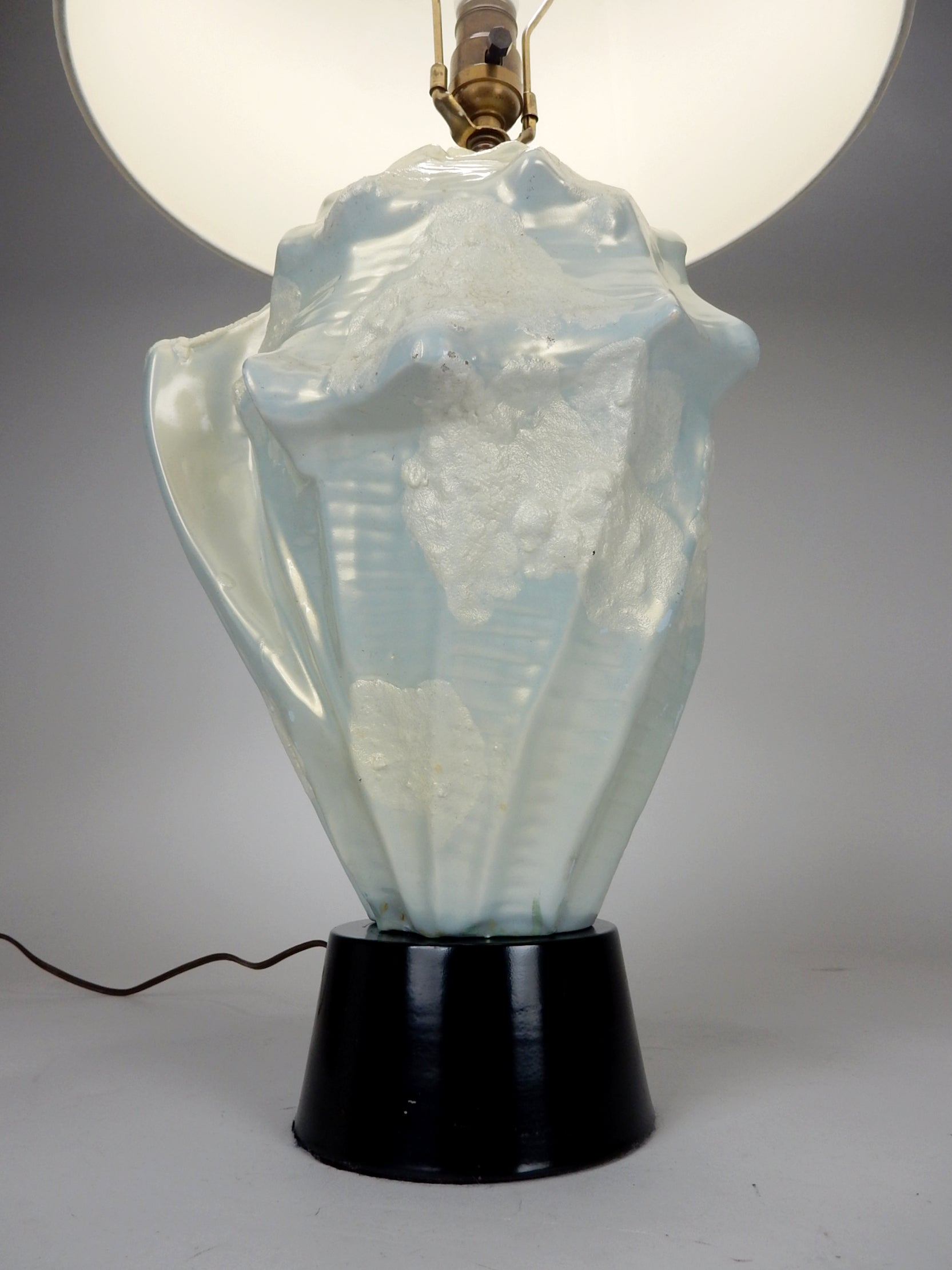 Ceramic Conch shell table lamp. This is really a stand out piece, gorgeous. 
Luminescent glaze makes it glow brilliant when lit.
Looks like a custom piece from circa 1960s judging by wiring and hardware. Black enamel metal base.
No damage, cracks