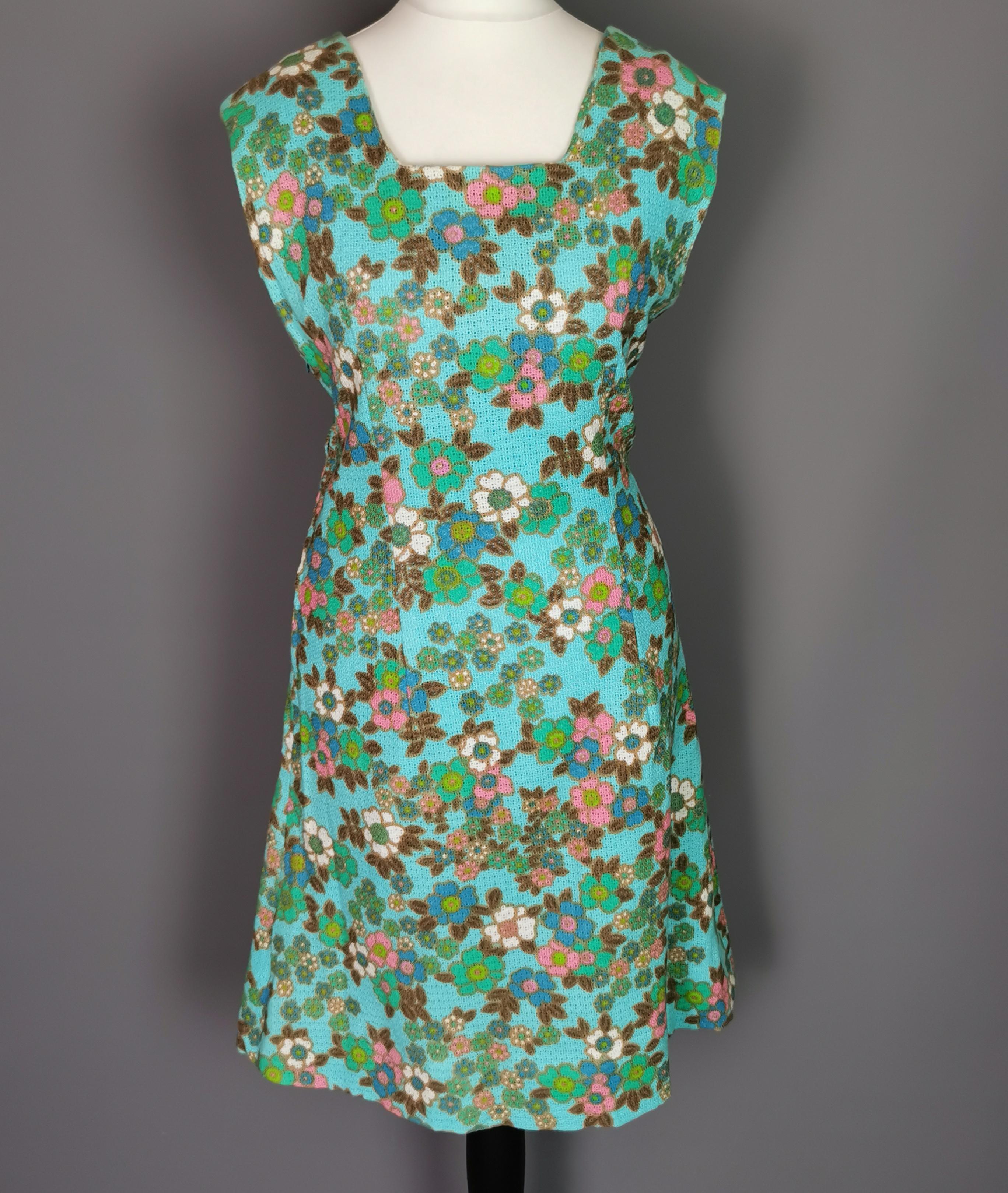 A fantastic vintage late c1960s flower power print mini dress!

It is made from a thick wool blend, nipped in very slightly at the waist with a fairly straight cut skirt in a vibrant floral pattern on a turquoise green ground, very colourful.

It