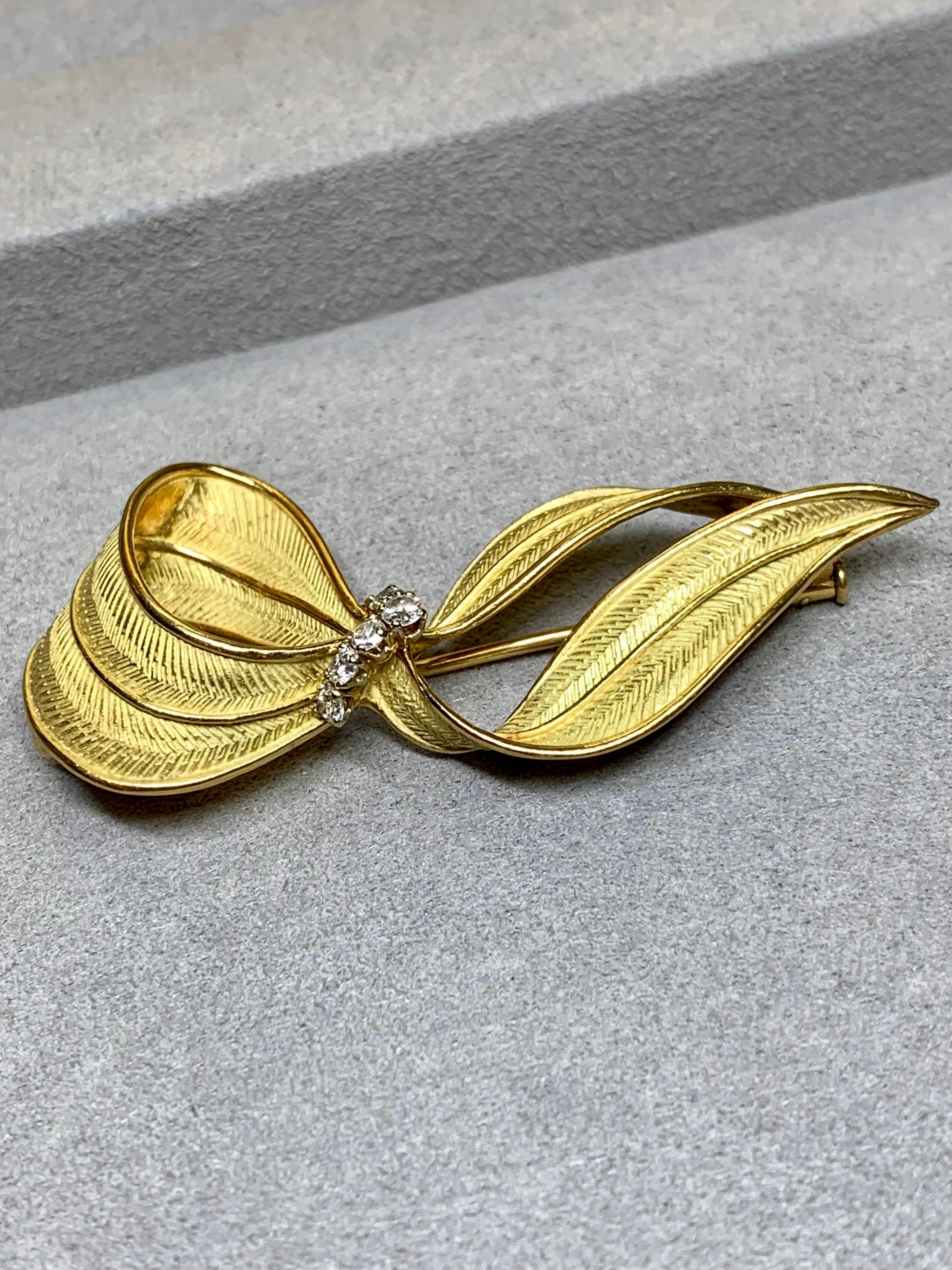 An exceptional French made brooch c. the 1960s done in textured 18K yellow gold and prong set with approximately .42ctw in G-H color Vs1 clarity round diamonds.


Dimensions/Weight:

Brooch measures 2.30” by 1.10” and weighs 12g.


Condition:

The