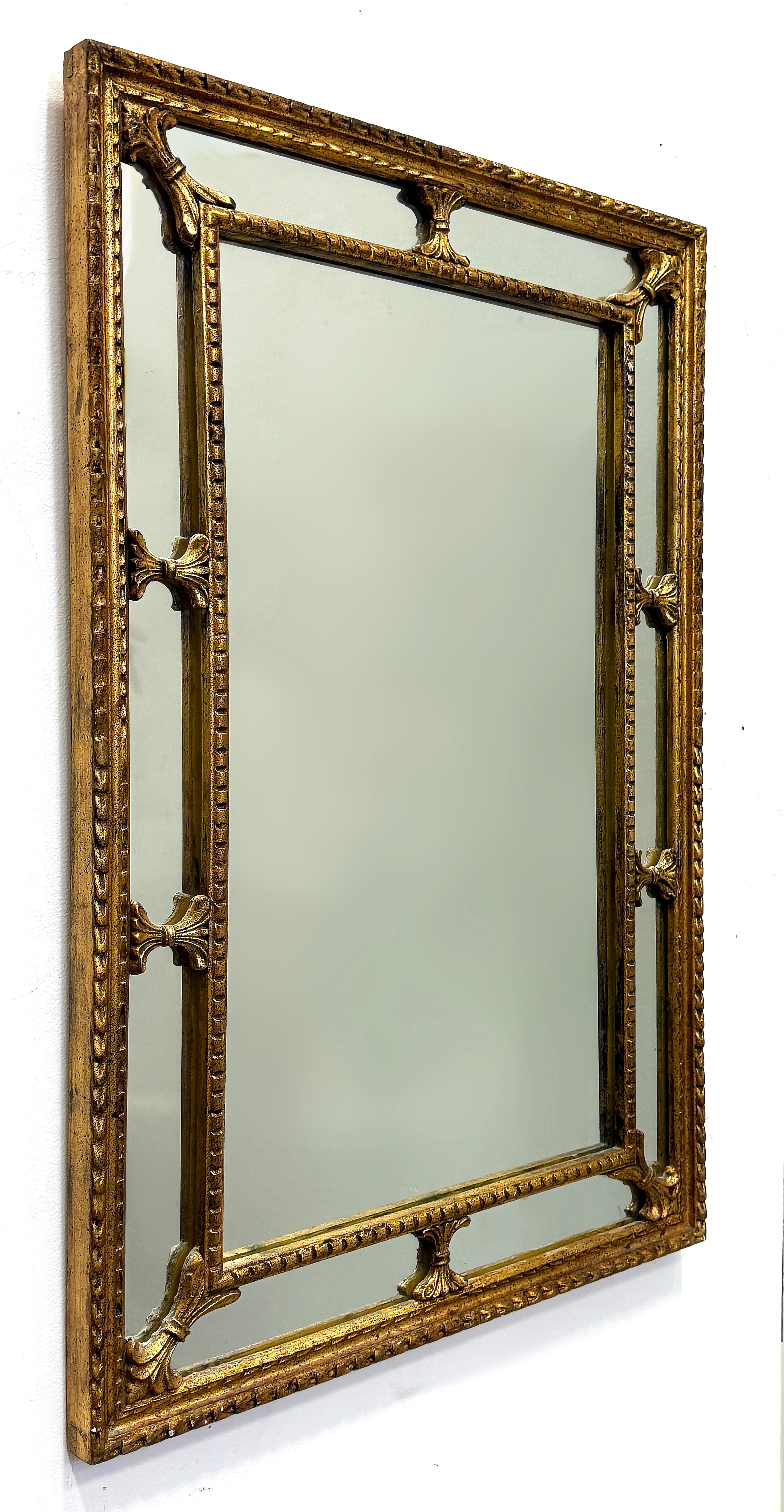 Miroir néoclassique en bois sculpté à la feuille d'or, Vintage 1960s 

Nous proposons à la vente un miroir en bois sculpté de style néoclassique datant des années 1960.  Le cadre en bois sculpté et doré est fini à la feuille d'or.  Le miroir central