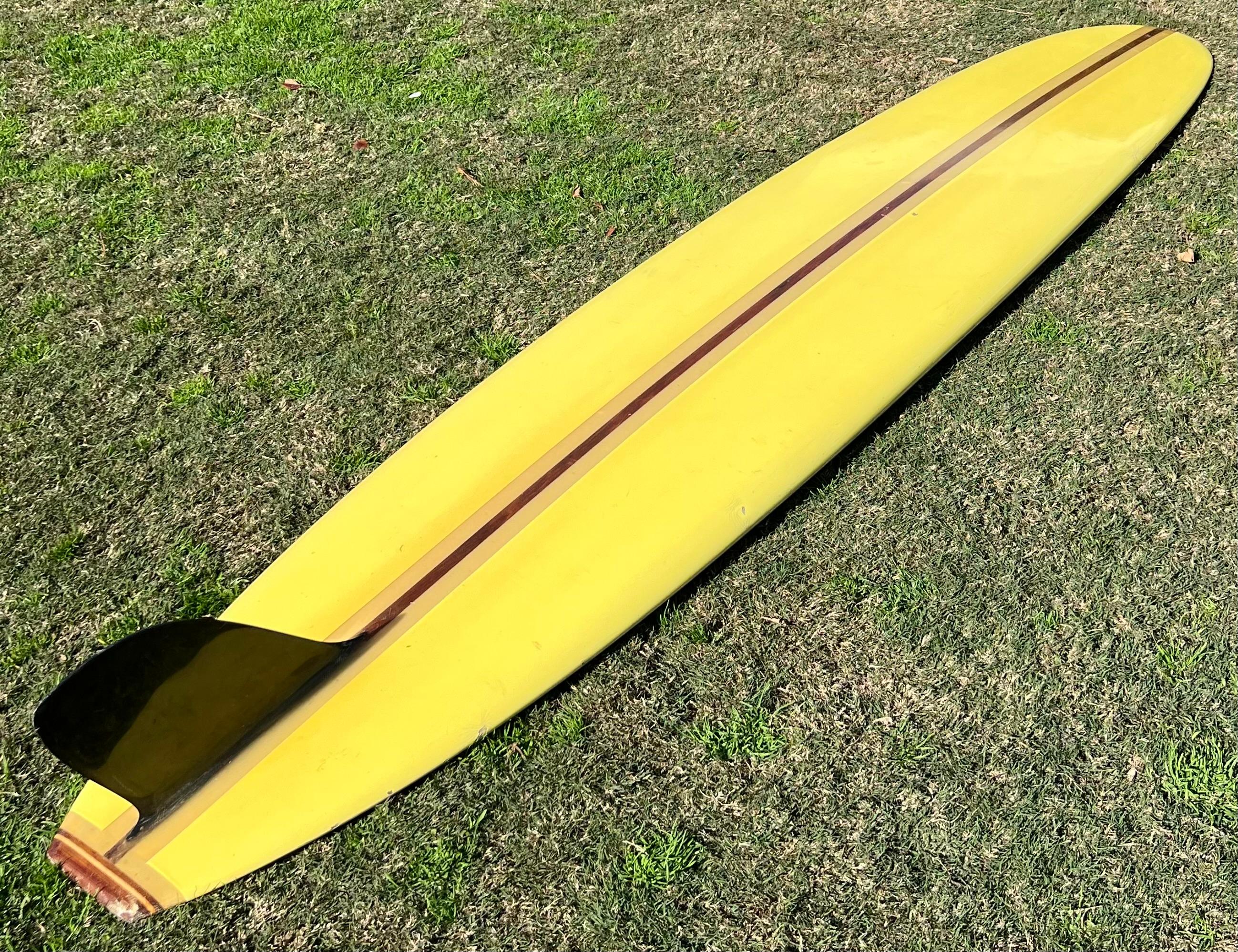 1960s Vintage Greg Noll custom longboard made in the mid 1960s. Features vibrant yellow pigment with Greg Noll atomic logo. Single redwood strigner with black single fin and 3-piece wood tailblock. All original condition. Made under the revered Greg