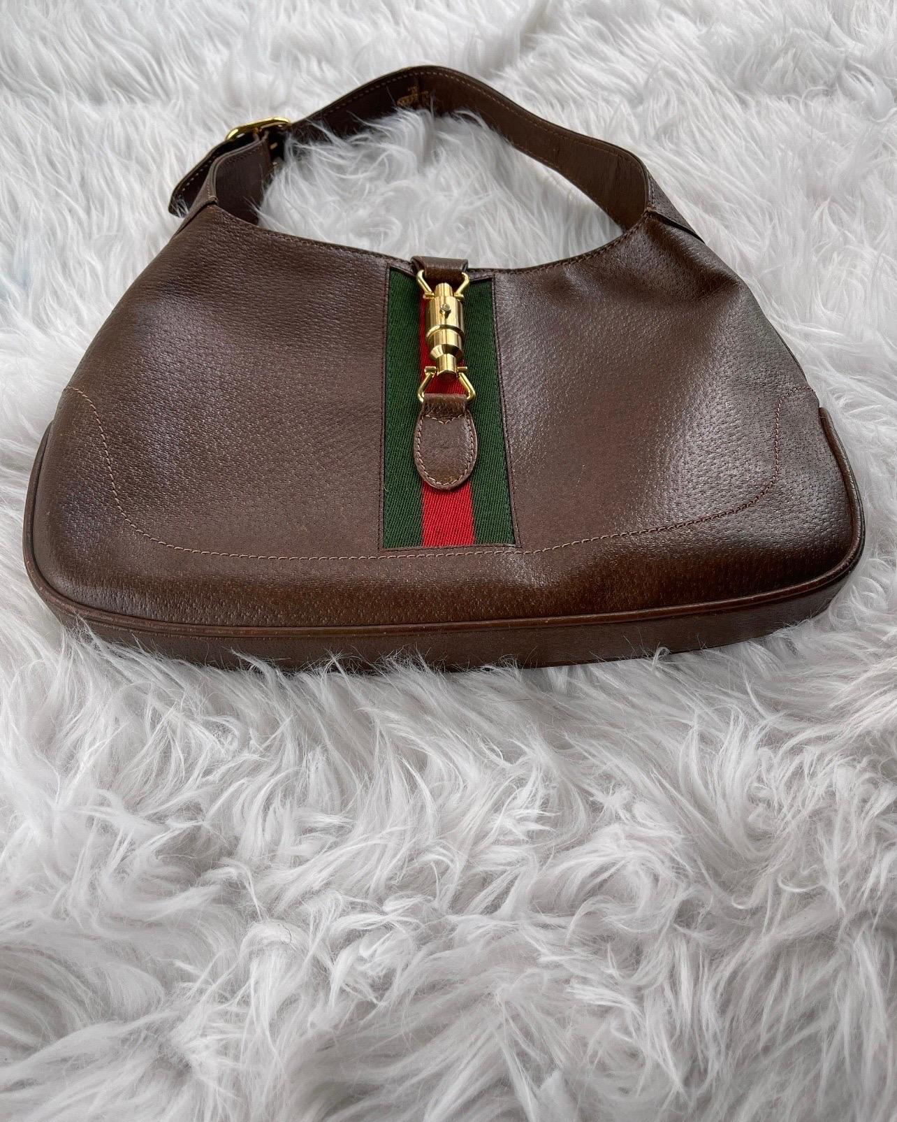 1960’s Gucci Brown Leather with Iconic Gucci web. This vintage Jackie O bag, in very good condition!

Condition:
Rich brown leather is super clean.
Green and Red Web Striped fabric is clean and in good condition. No rips or holes. 
Gold hardware