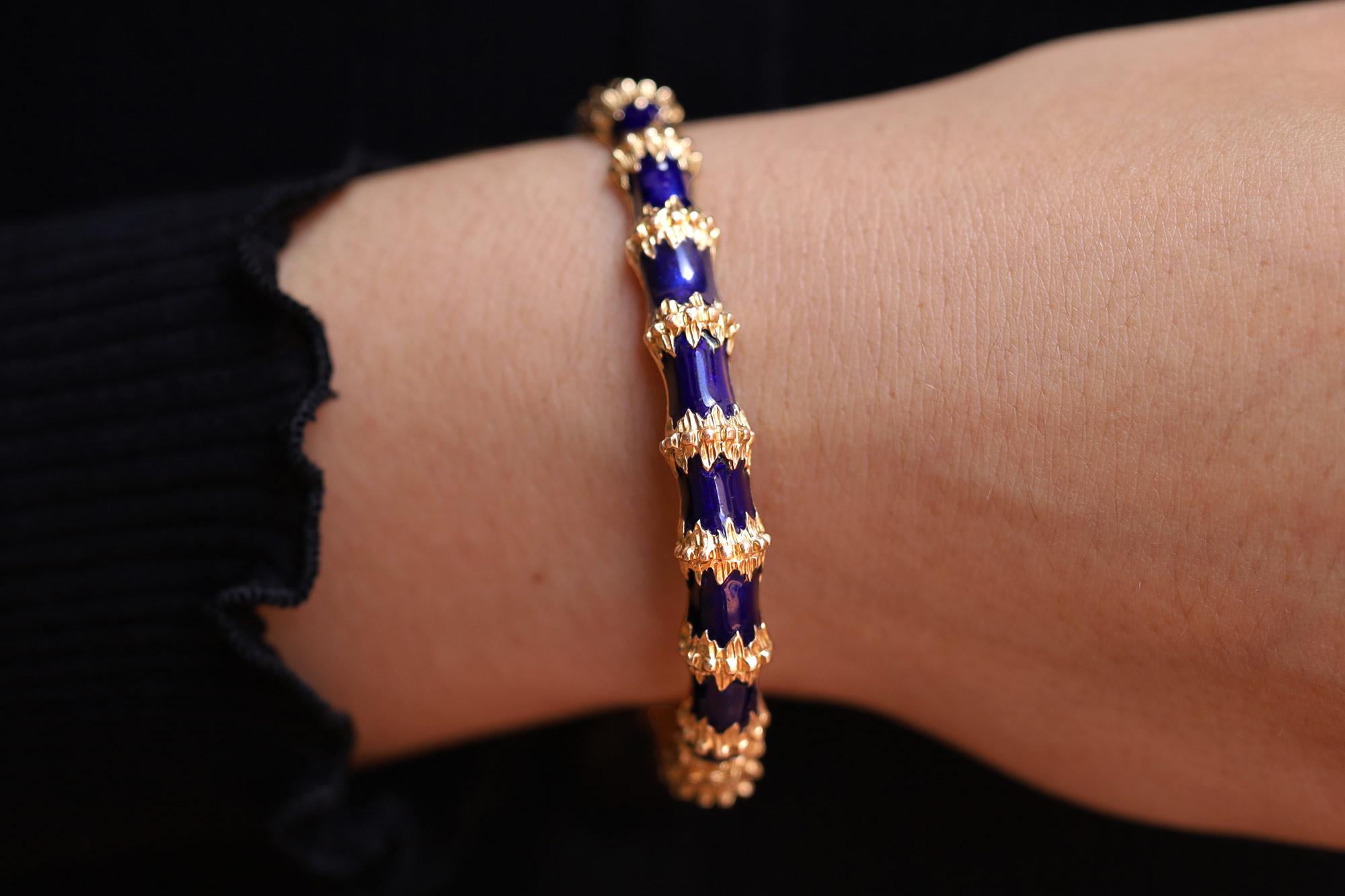 A peerless design exemplified by this vintage 1960's Brutalist blue enamel bangle bracelet by Jack Gutschneider.. Weighing 27.9 grams in 14 karat yellow gold. Featuring an avant-garde design embellished with rich, royal blue enamel, this eminently