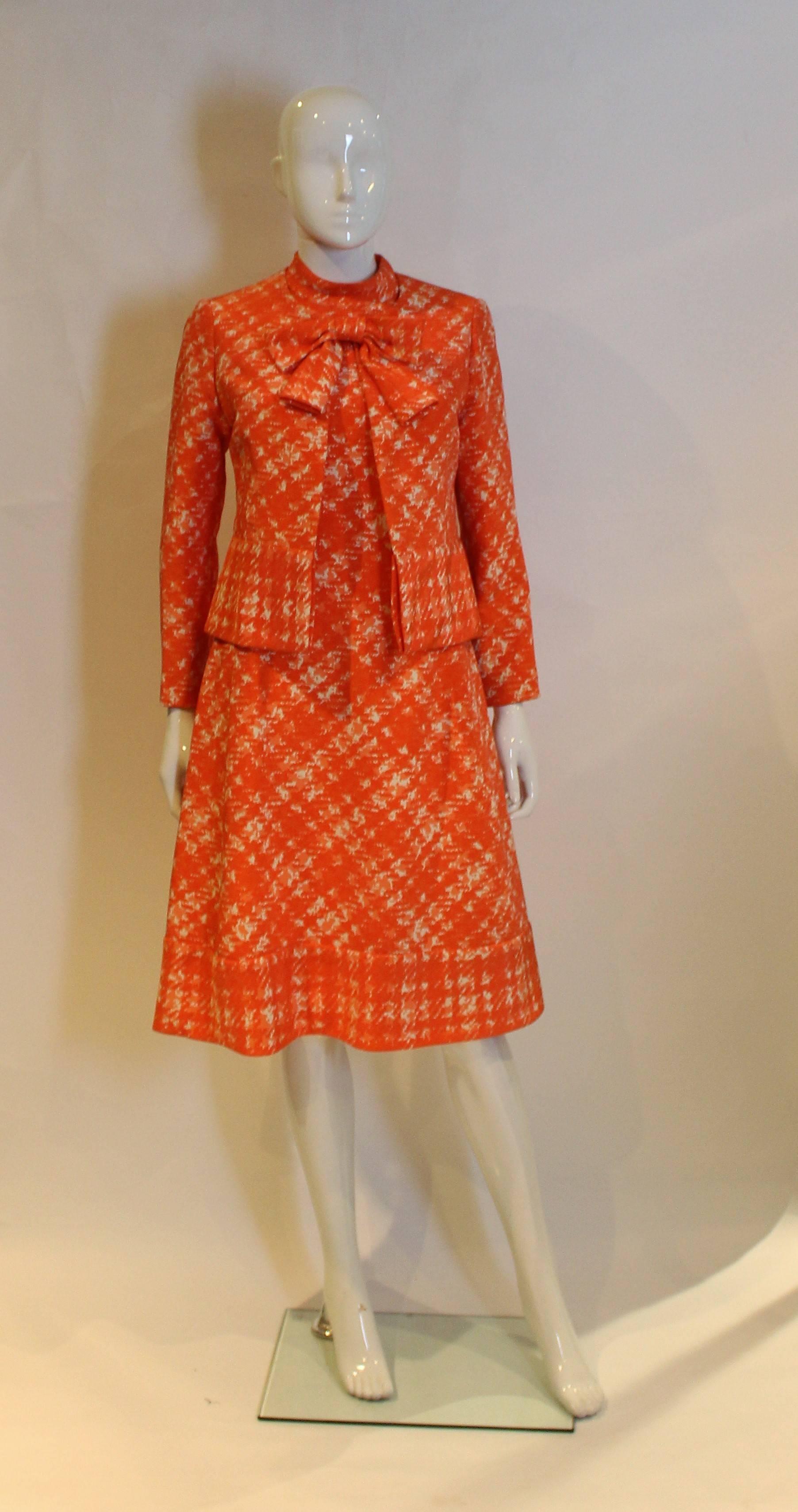This is a stunning piece and so wonderfuly constructed. The fabric is a wonderful orange and ivory print, with a super silk lining and an inner lining of tuile like fabric. The dress has a central back zip and two large decorative buttons. There is