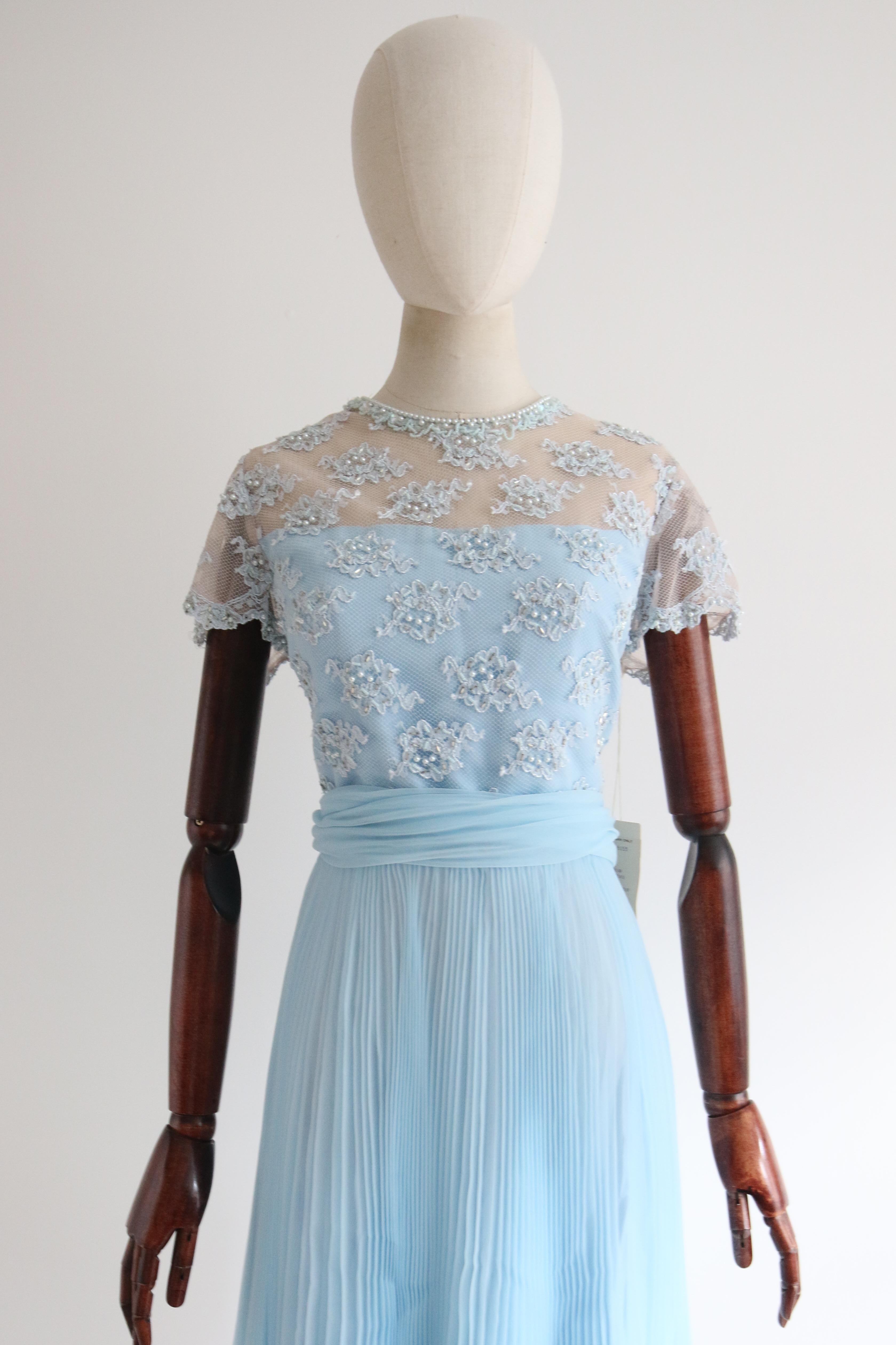 An eye-catching piece to behold this original 1960's dress, rendered in a blue floral lace which is in turn embellished with blue pearlescent beads, small pale blue glass bead and silver bugle beads, contrasting the effortless sky blue pleated