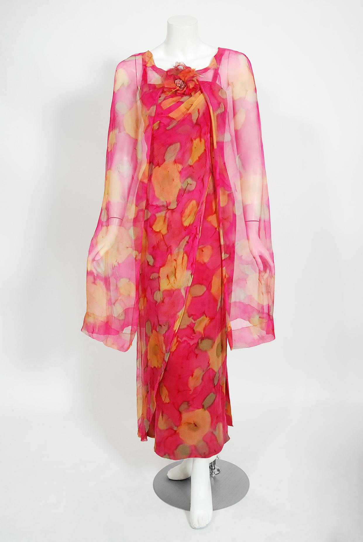 A stunning two-piece dress ensemble by Parisian couturier Jean LeFebure, who operated a small couture house during the 1950's and 1960's. The stunning magenta-pink, marigold and green watercolor floral silk chiffon used for this garment has a fresh