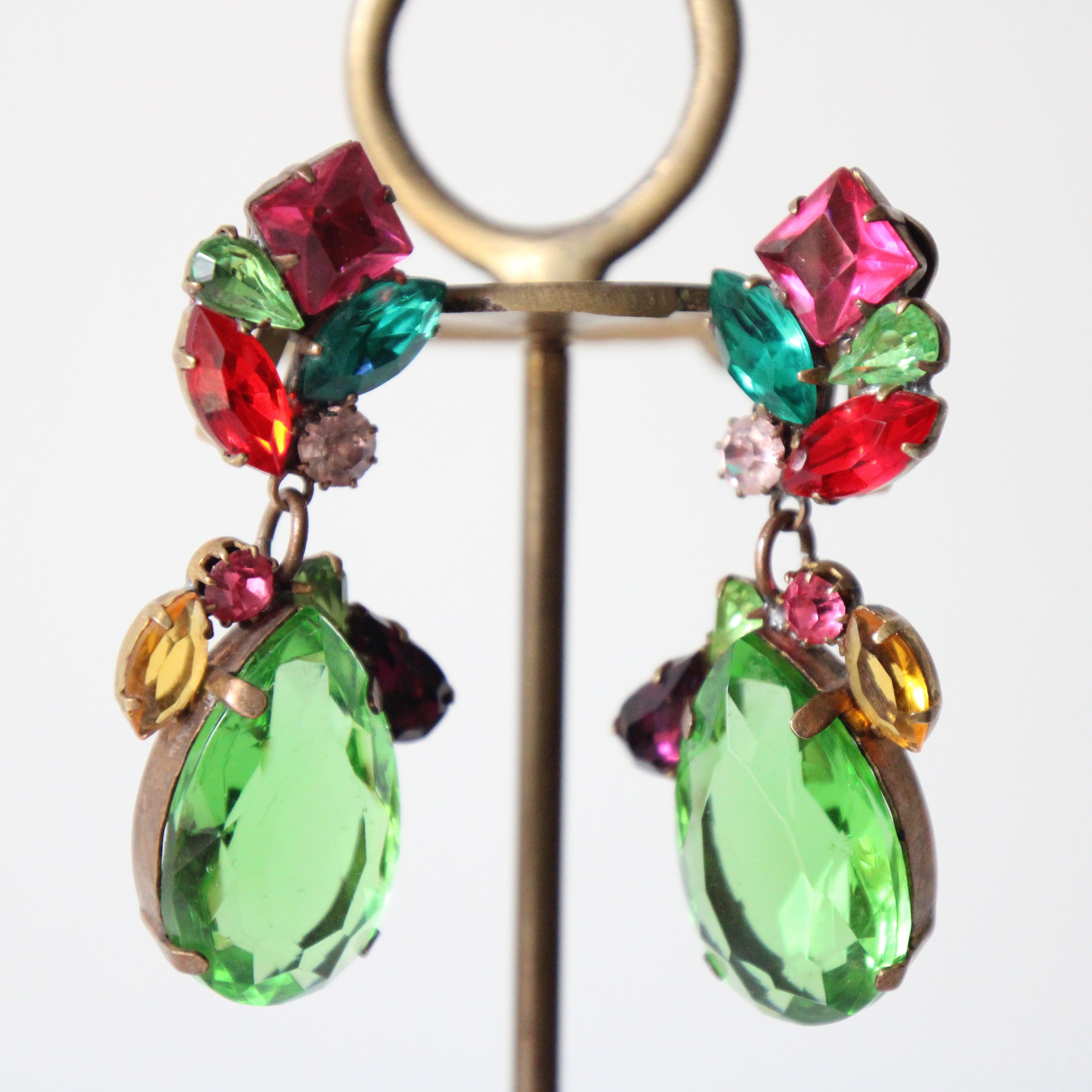 This wonderful pair of 1960's clip on earrings, on a brass metal coloured base, showcasing an array of glass claw set rhinestones, in jewelled tones of pink, turquoise, green, red and pink, are the perfect statement to your jewellery collection. The