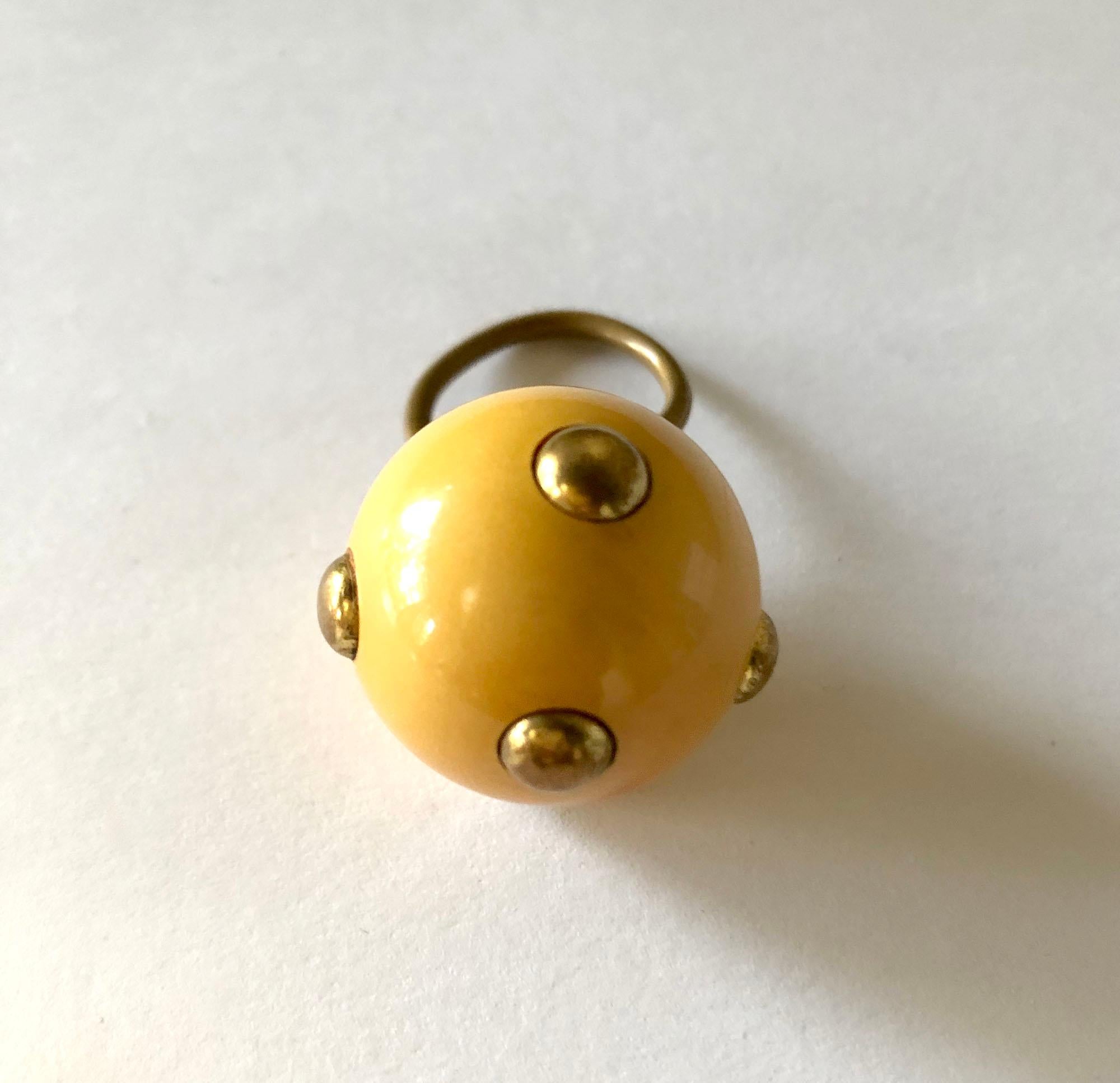 Vintage 1960's beige tone bakelite ring with brass studs made by Kenneth Jay Lane, New York.  Ring is currently a finger size 6.75, is slightly adjustable and a bit out of round. Ball is 1