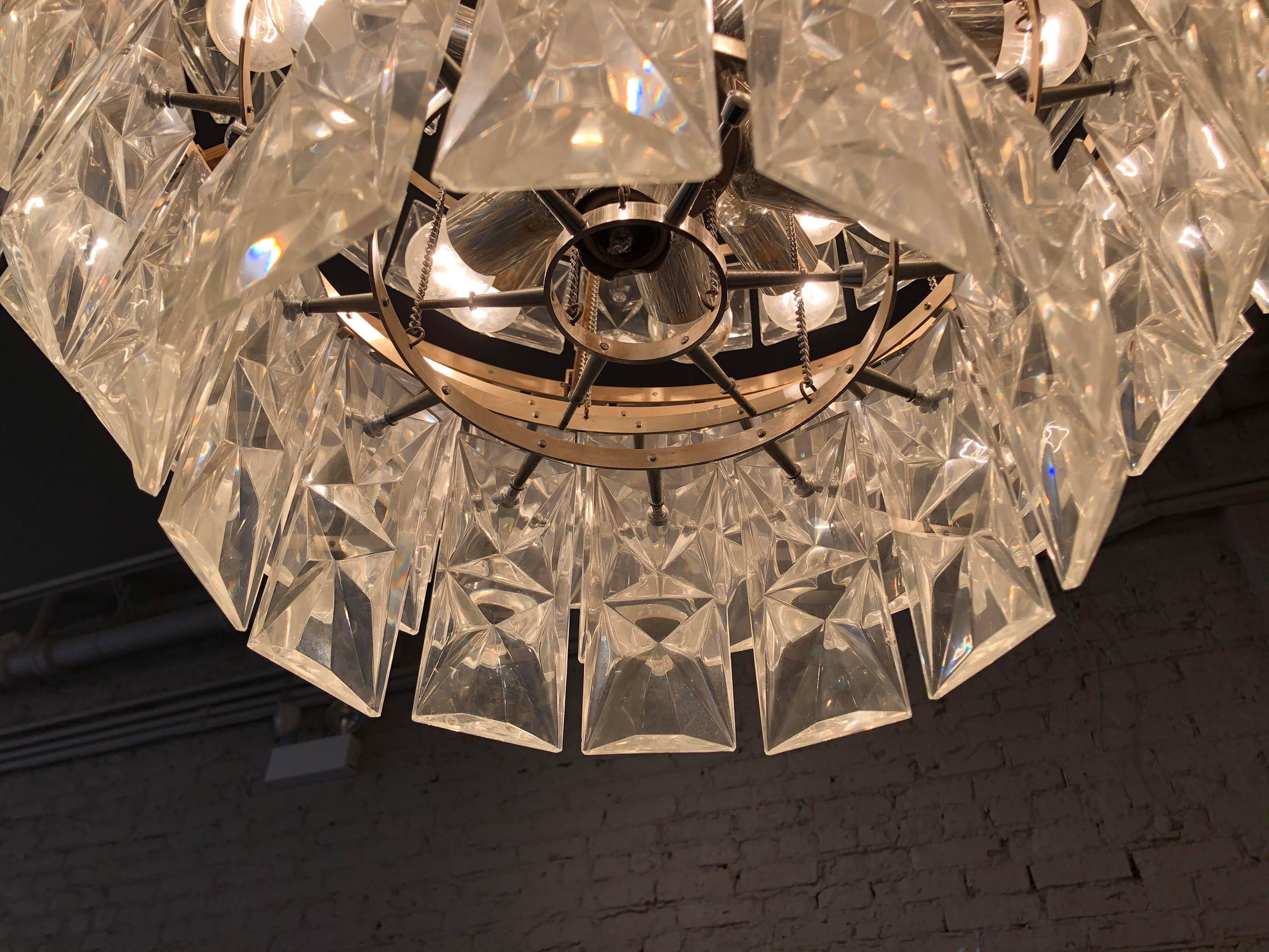 Gorgeous chandelier made of huge glass crystals. Each piece is screwed in place with fasteners. The chandelier was missing a few hard to find crystals so the previous owner was clever in removing the innermost tier crystals to replace the missing