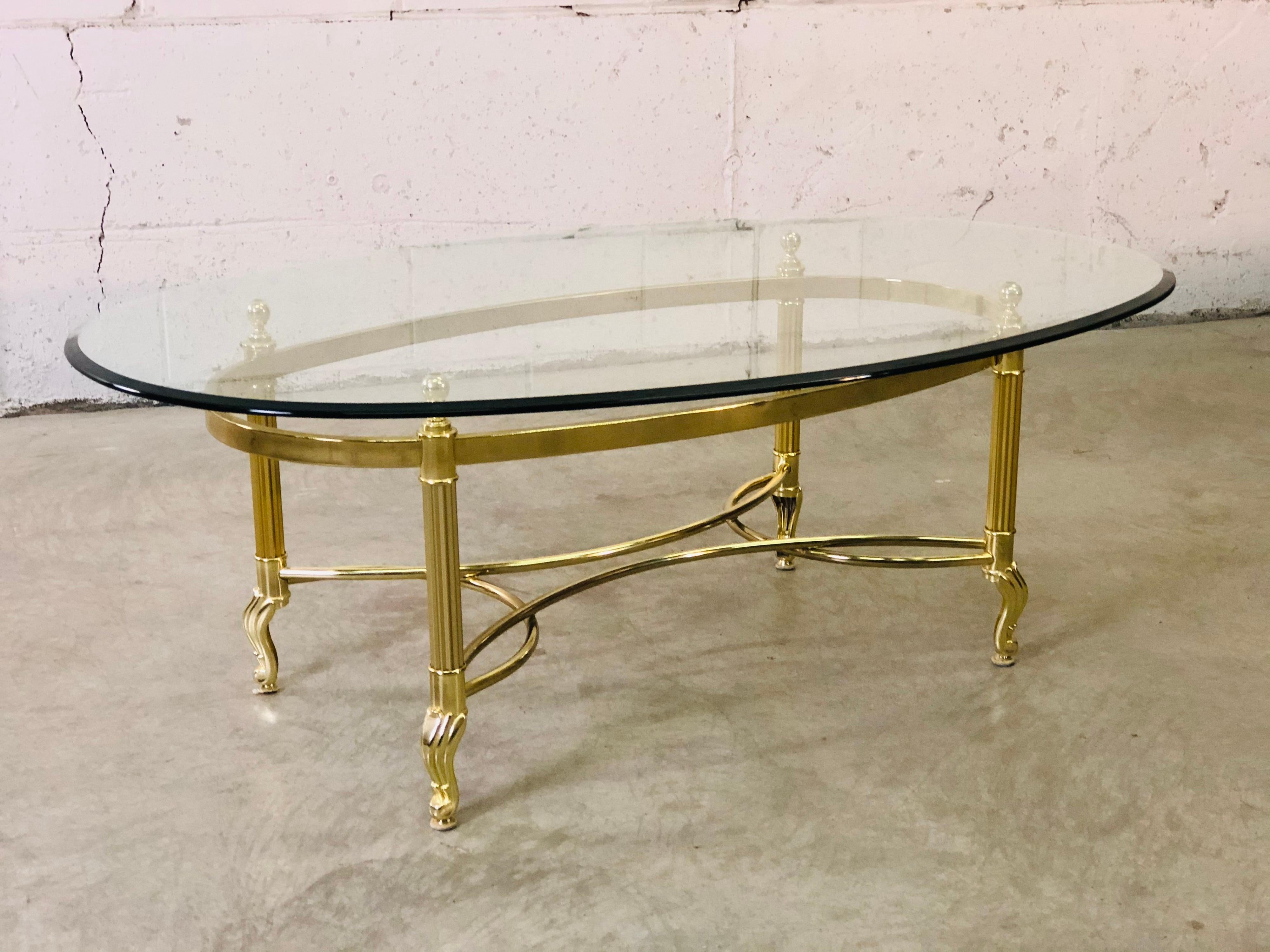 Vintage 1960s LaBarge brass base and glass top oval coffee table with scroll feet. Light tarnish from use in spots. No marks.