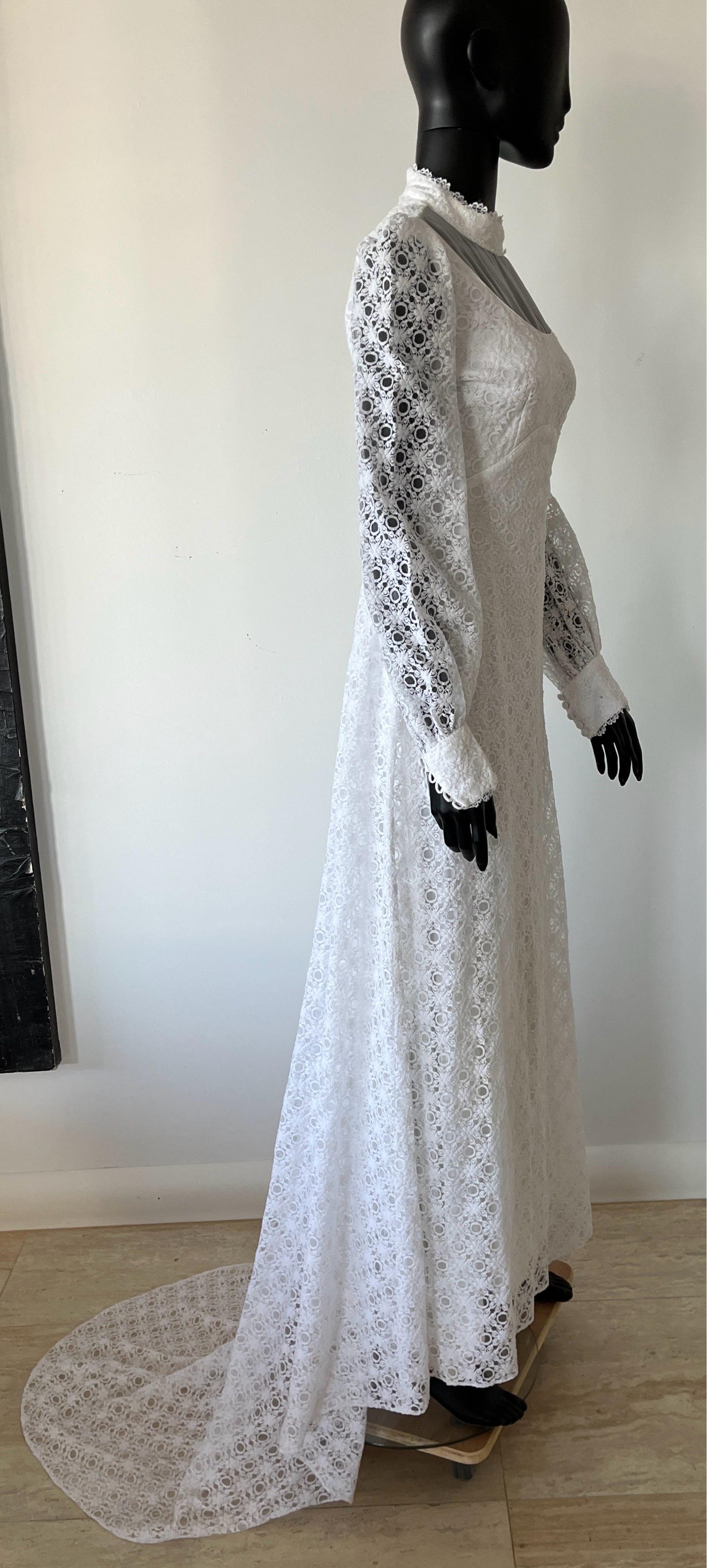 Splendido abito da sposa vintage anni '60 in pizzo guipure a margherita di colore bianco. Presenta un pannello di chiffon trasparente, maniche arricciate con bottoni e un bellissimo strascico posteriore.
Taglia piccola. 