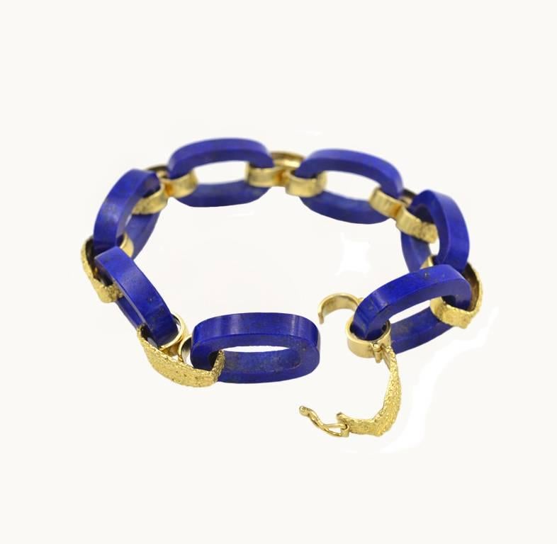 A vintage lapis lazuli and 18 karat yellow gold link bracelet from circa 1960s.  This awesome bracelet features 7 oval lapis lazuli pieces that each measure about 23.5 mm by 15 mm.  Alternating between the lapis lazuli pieces are 7 textured gold