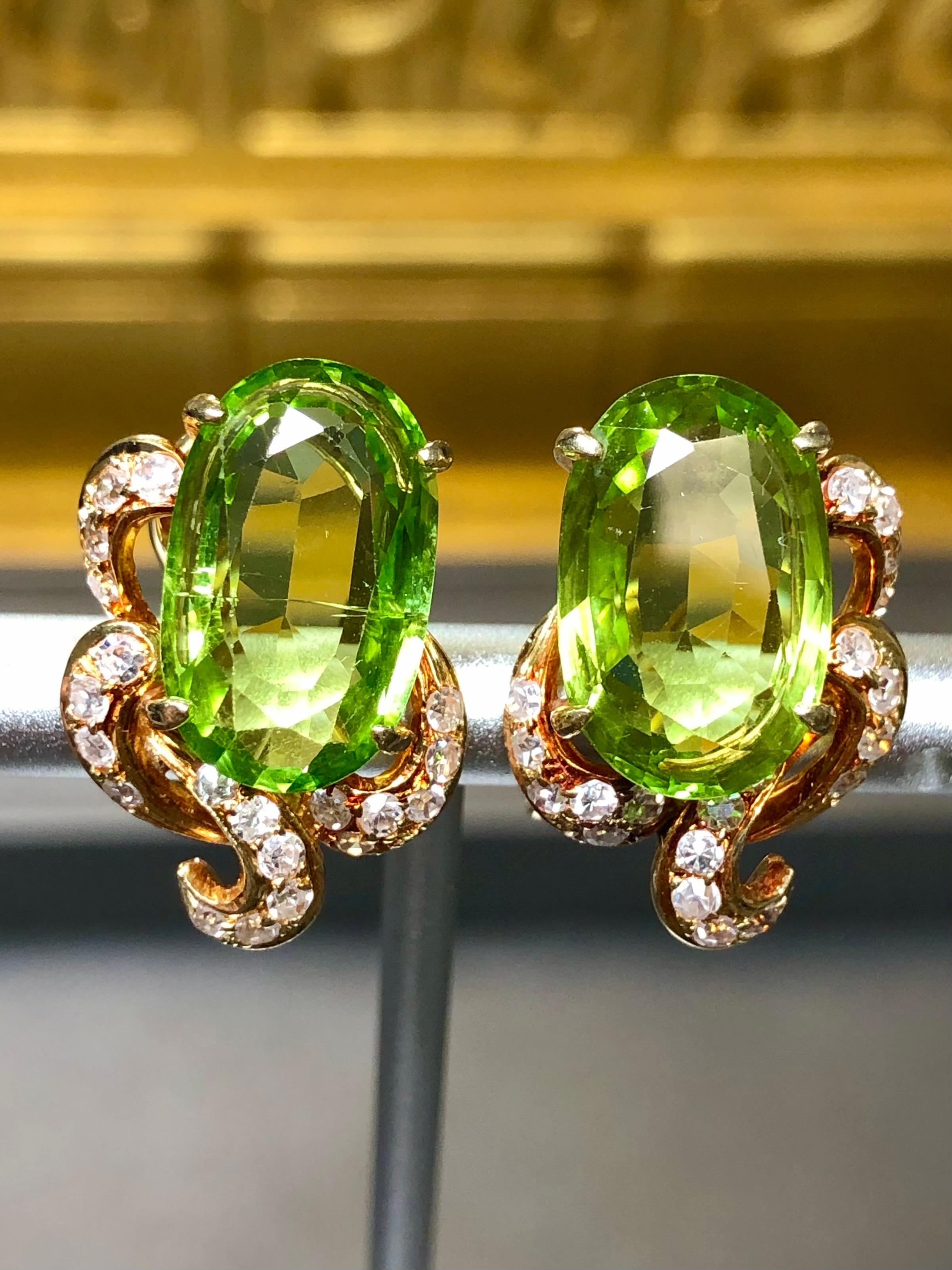 A gorgeous pair of vintage earrings done in 18K yellow gold displaying lovely patina and centered by approximately 10cttw in natural oval cut peridot which are surrounded by approximately .50cttw in F-G color Vs1-Si1 clarity round diamonds. These