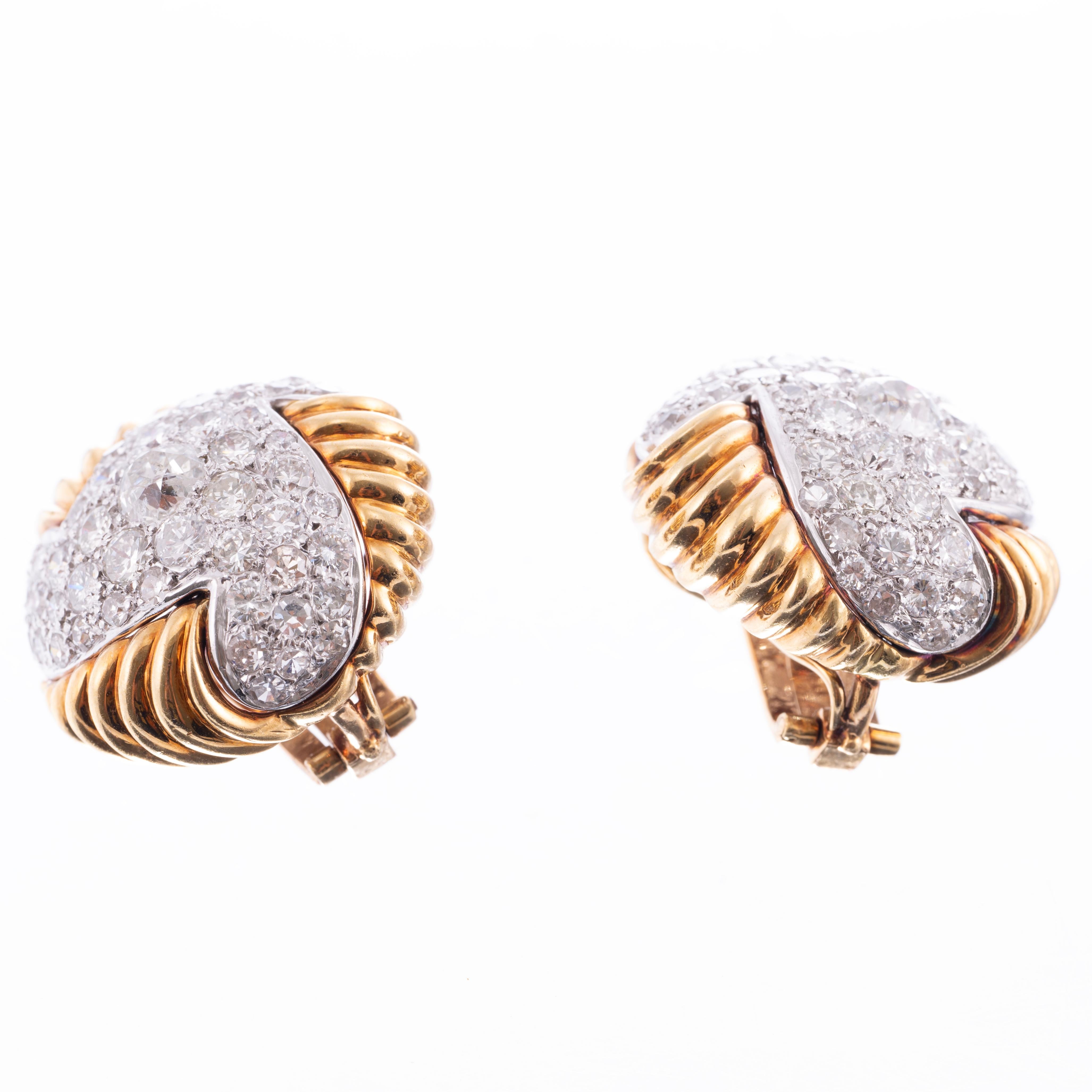 Authentic design from the 1960's, these stylish diamond and 18k yellow gold earring are identifiably vintage. The pavé diamond design is enhanced due to the combination of selection of multiple cuts of rounds diamonds matching in color and quality.