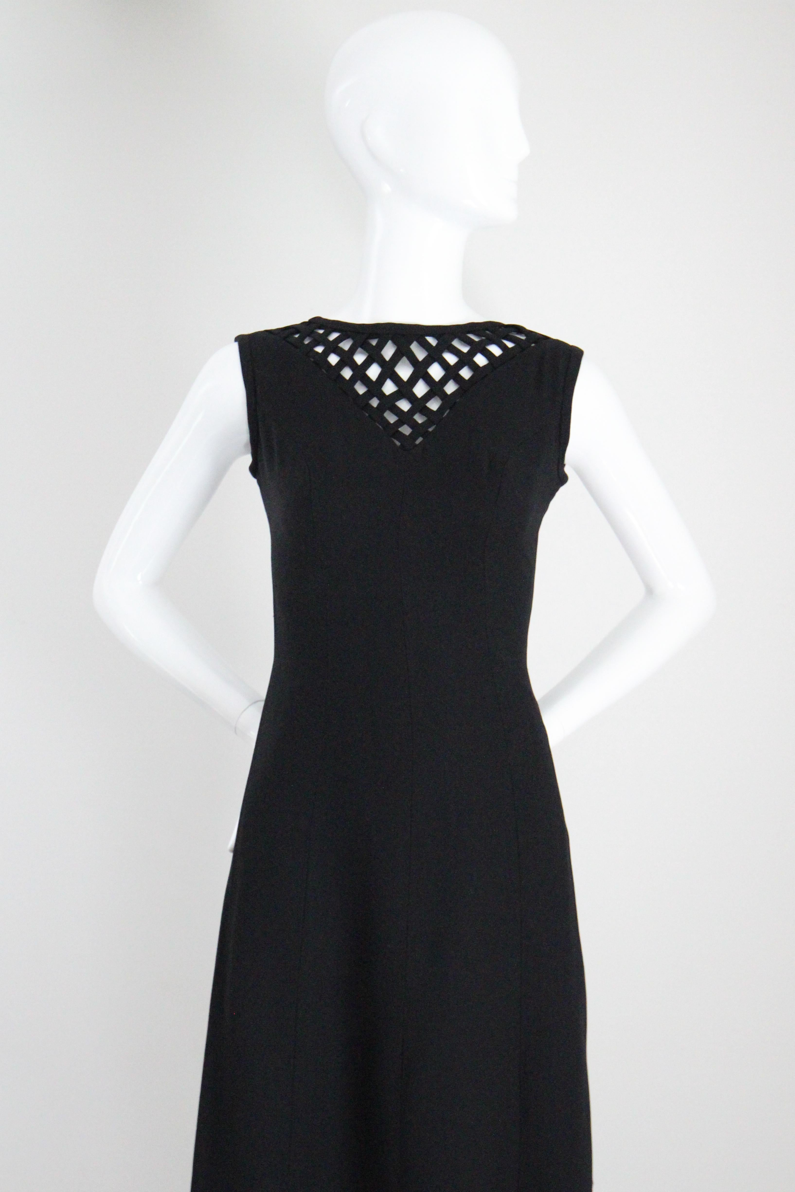 Dieses schwarze Crêpe-Kleid aus den frühen 1960er Jahren ist perfekt geschneidert, um Ihre Sammlung von kleinen schwarzen Kleidern zu ergänzen. 
Der runde Ausschnitt wird durch ein V-förmiges gewebtes Gittermuster entlang des Dekolletés akzentuiert.