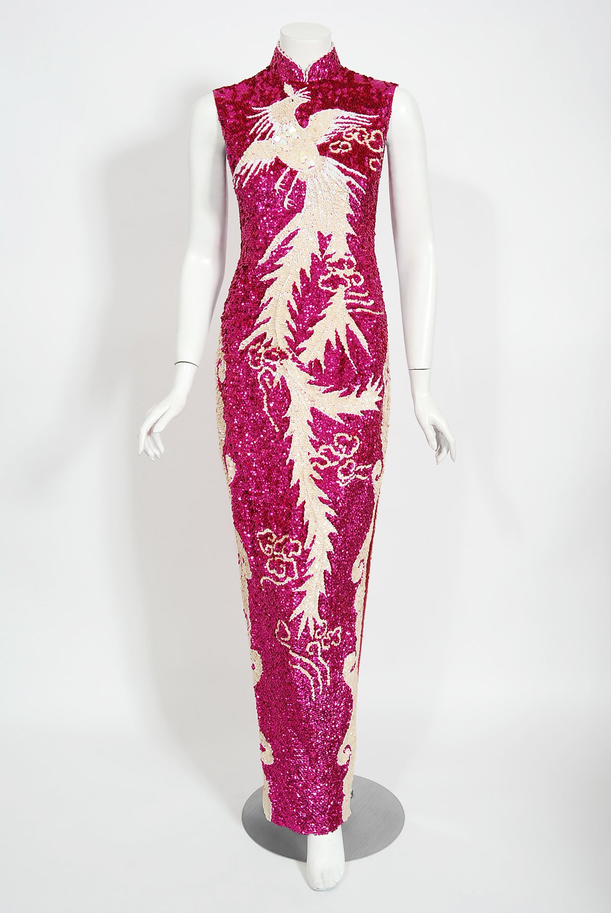 A sensational fully-sequin magenta pink hourglass cheongsam gown dating back to the mid 1960's. This showgirl showstopper has fantastic three-dimensional sequins which really dazzles the eye. A dramatic flying phoenix bird motif is worked in with