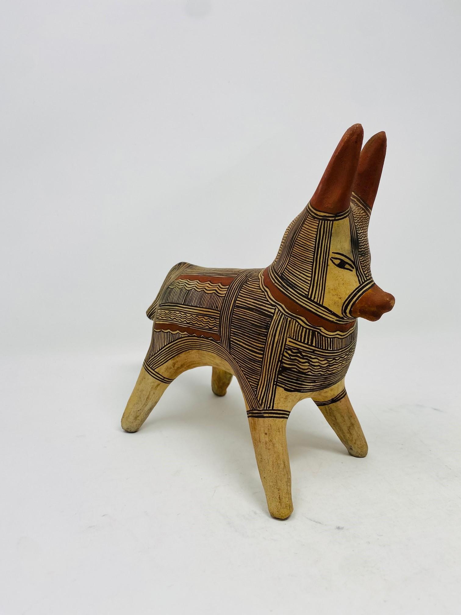 Incredibly charming and stylish pottery-clay donkey sculpture from Mexico.  This unique piece is its own one of a kind that shows craftmanship and style.  The sculpture presents the figure in a solid stance.  The figure is colored in a clay finish