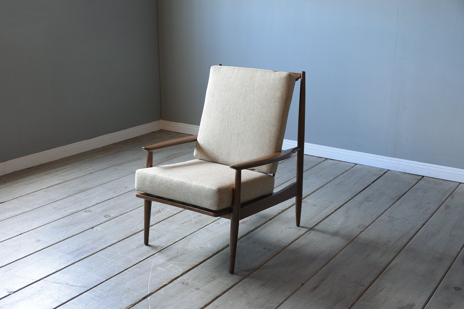 This vintage 1960s mid-century modern upholstered lounge chair is crafted out of walnut wood with the original rich walnut color stain with a polished finish and has been completely restored by our team of expert craftsmen. The chair frame features