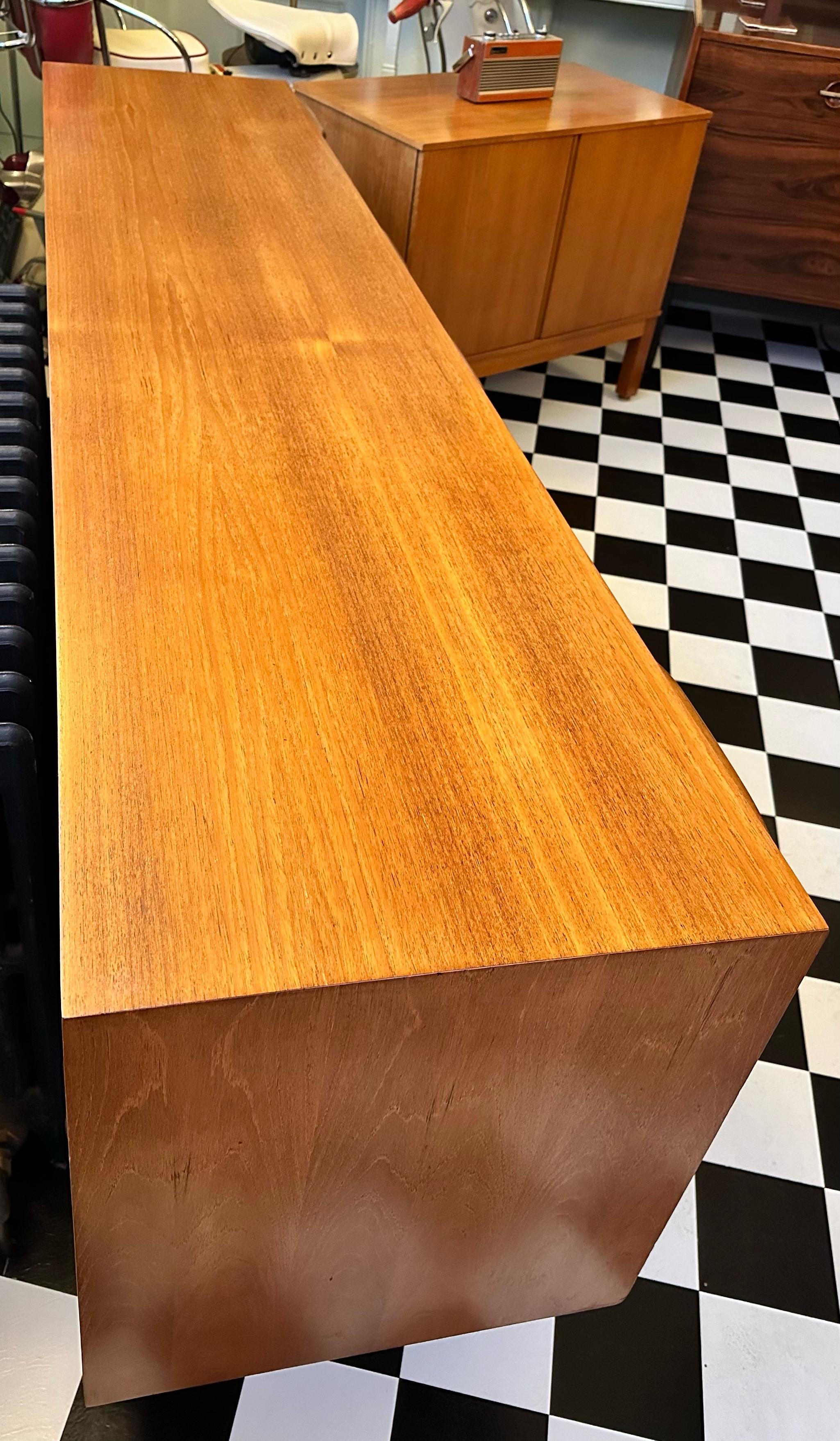 

Beautiful mid-century teak sideboard designed by Tom Robertson and manufactured by A.H. McIntosh of Kirkcaldy, Scotland circa 1960s. The sideboard features three drawers (top one has a fitted cutlery compartment), spacious cupboard with one