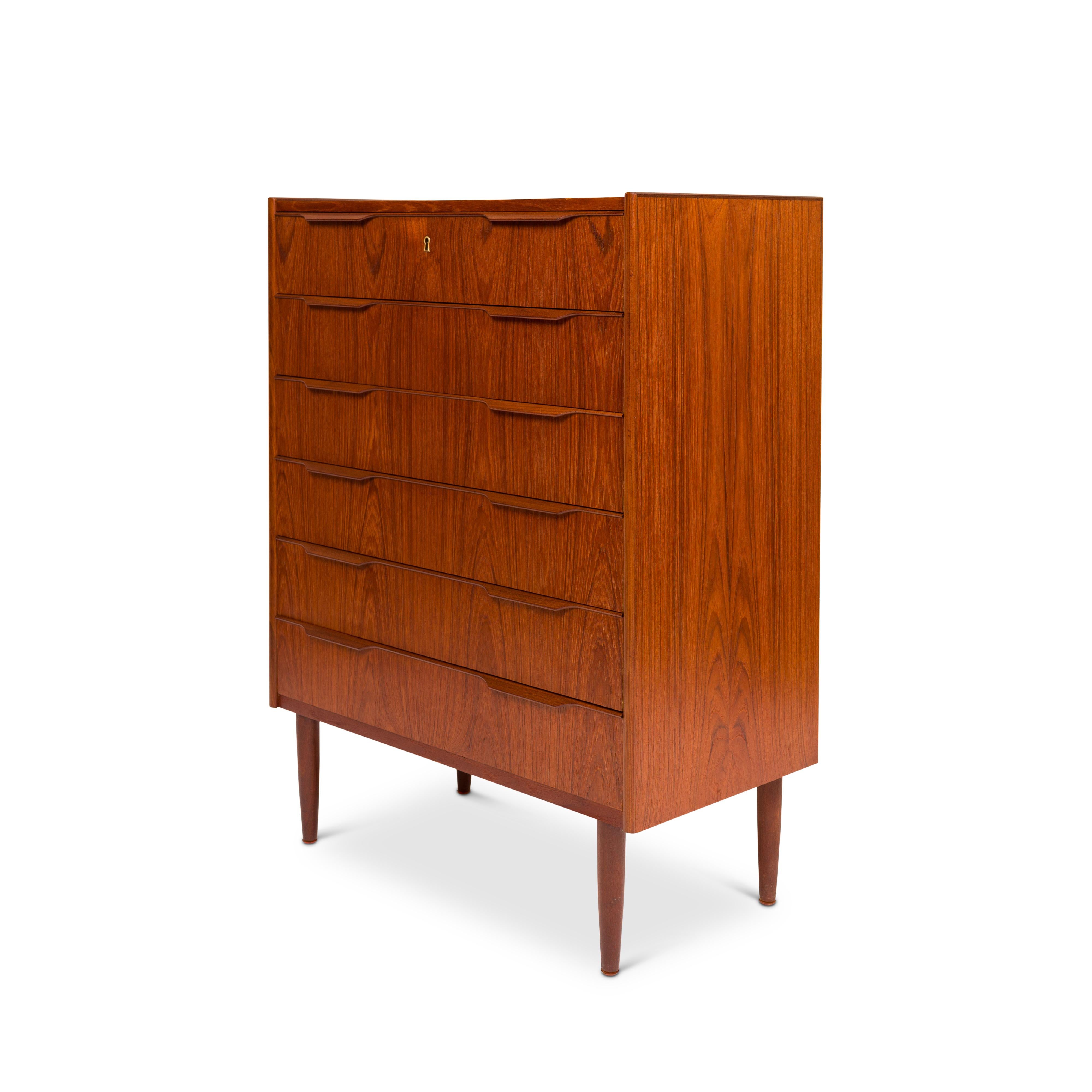 Crafted with meticulous artistry in 1960s Denmark, this stunning modern Danish mid-century Teak Tallboy stands as a testament to unparalleled craftsmanship. Its allure lies in the exquisite teak wood-grain detailing that adorns the tallboy dresser,