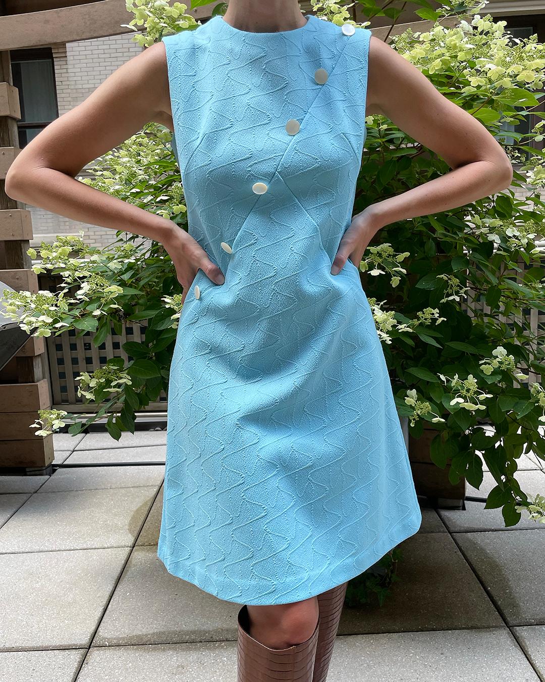 This dress was made in the early 1960s, and is very much in the style of Pierre Cardin, who really ushered in the Space Age craze of that era. Recently we've seen this mod, Space Age style trending on the runways, so it's very fun to get that look