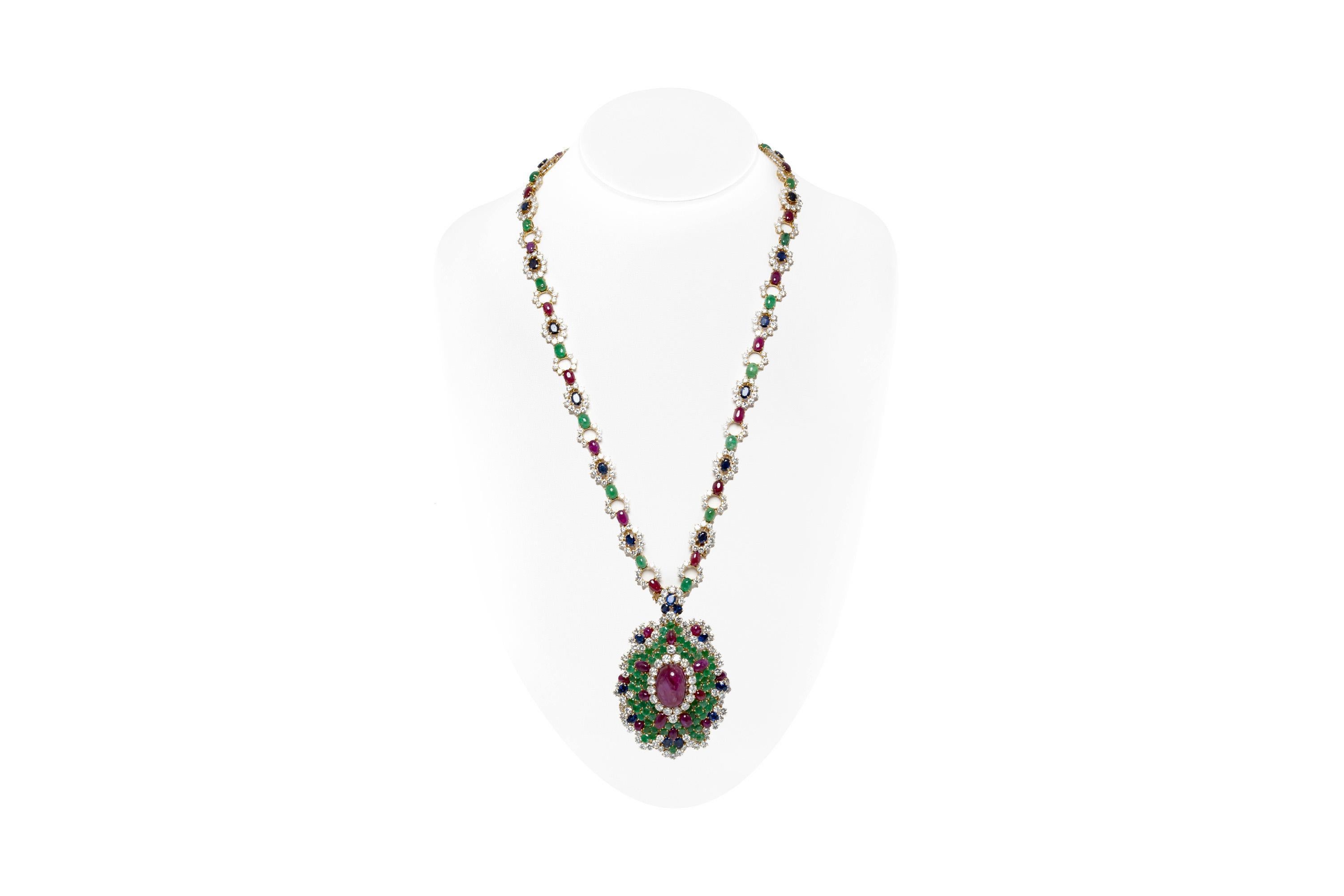 Finley crafted in 18k yellow gold with a center Cabochon Ruby weighing approximately 28.00 carats, additional 35 Cabochon Rubies weighing approximately a total of 31.50 carats, 21 Cabochon and 68 Round cut Emeralds weighing approximately a total of