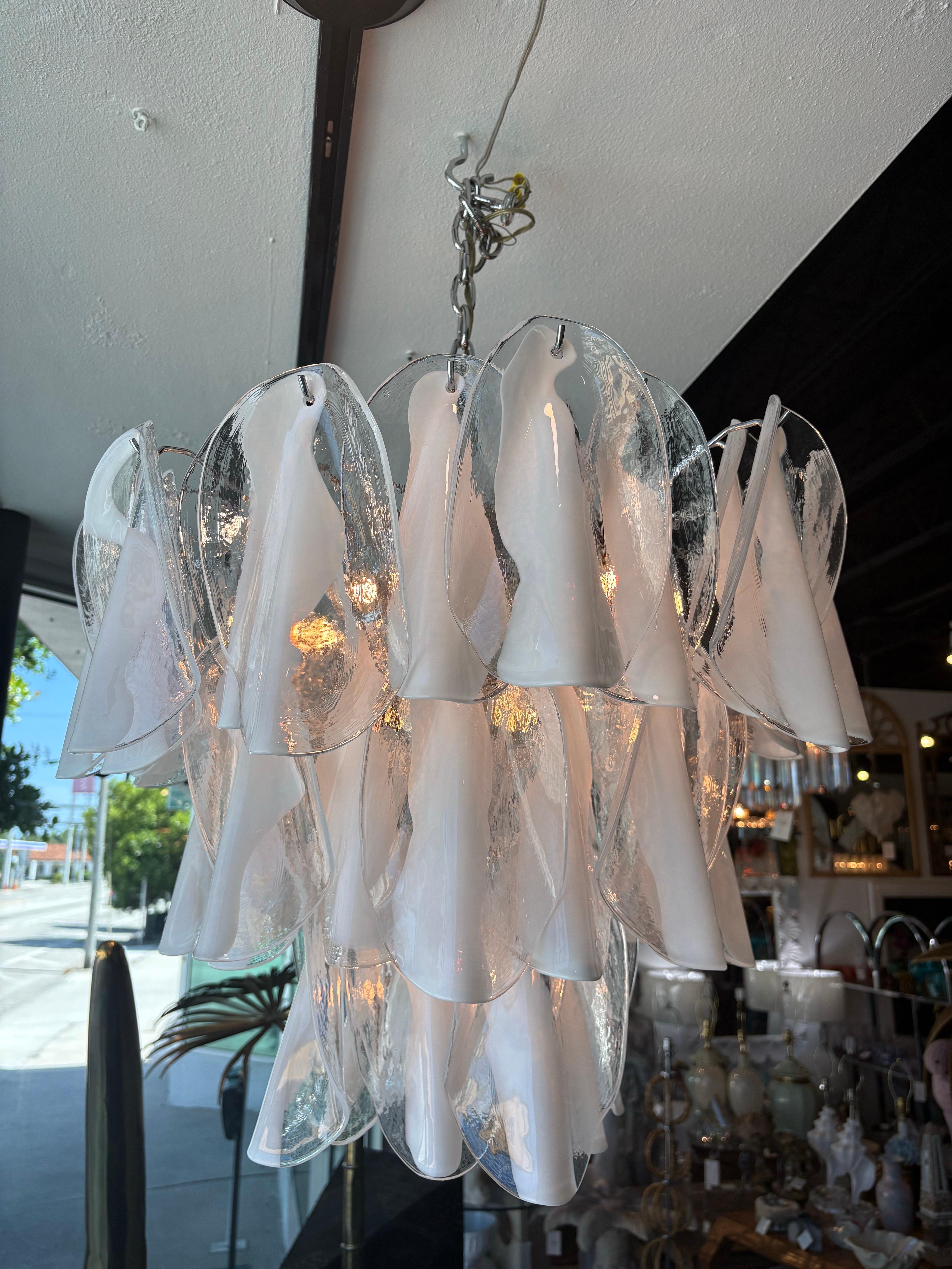 Incredibile lampadario Mazzega Murano vintage degli anni '60, a tre livelli. Viene fornito con catena e tettuccio originale. La gabbia cromata presenta una leggera patina dovuta all'età. Il vetro è tutto presente e non presenta schegge. Abbiamo