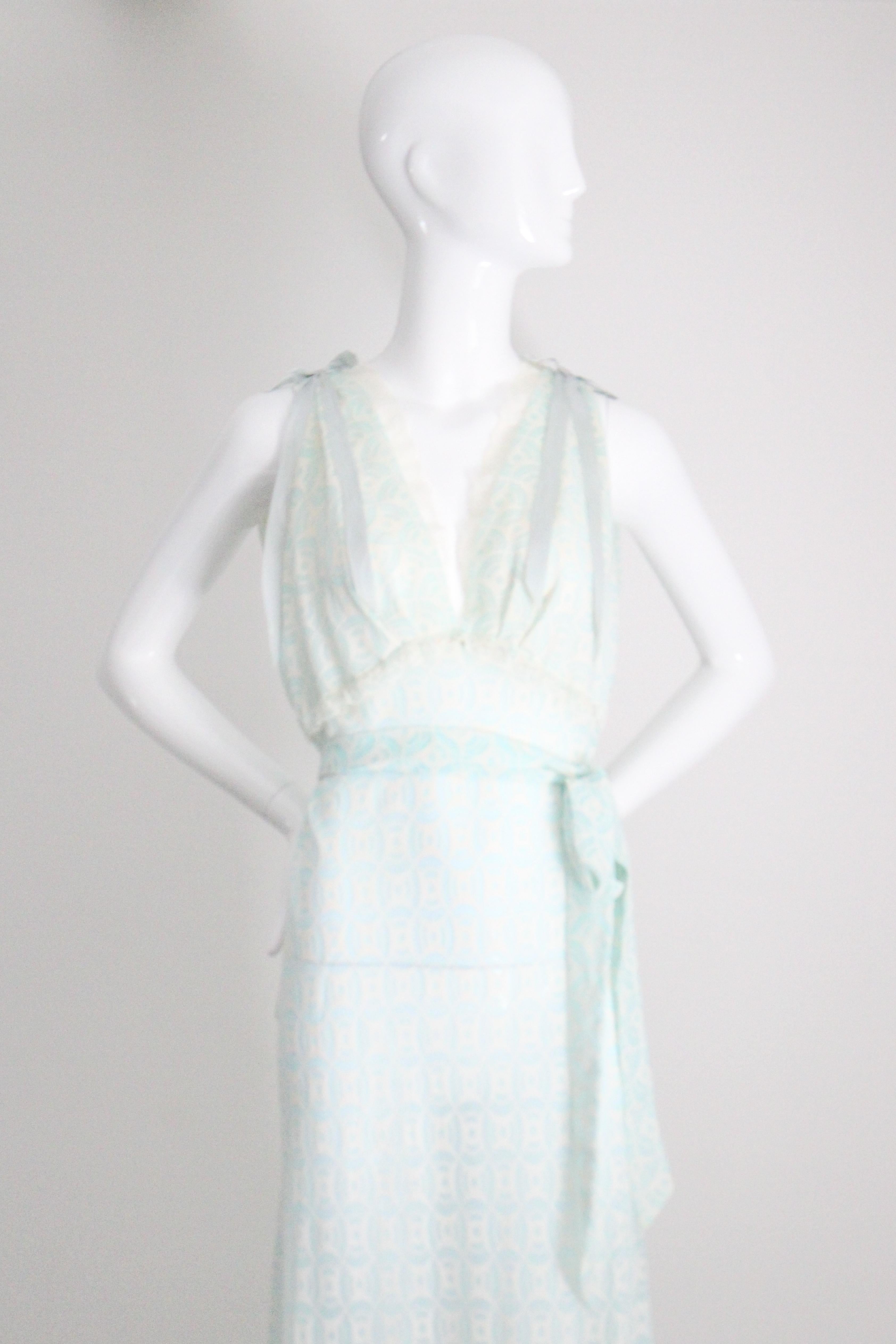 Dieses elegante Nachthemd aus den 1960er Jahren mit kreisförmigem Art-Déco-Muster in arktischen Blau- und Cremetönen und cremefarbenen Spitzenabschlüssen ist genau das Richtige für Ihre Dessous-Kollektion. 

Das V-förmige Dekolleté ist mit zarter