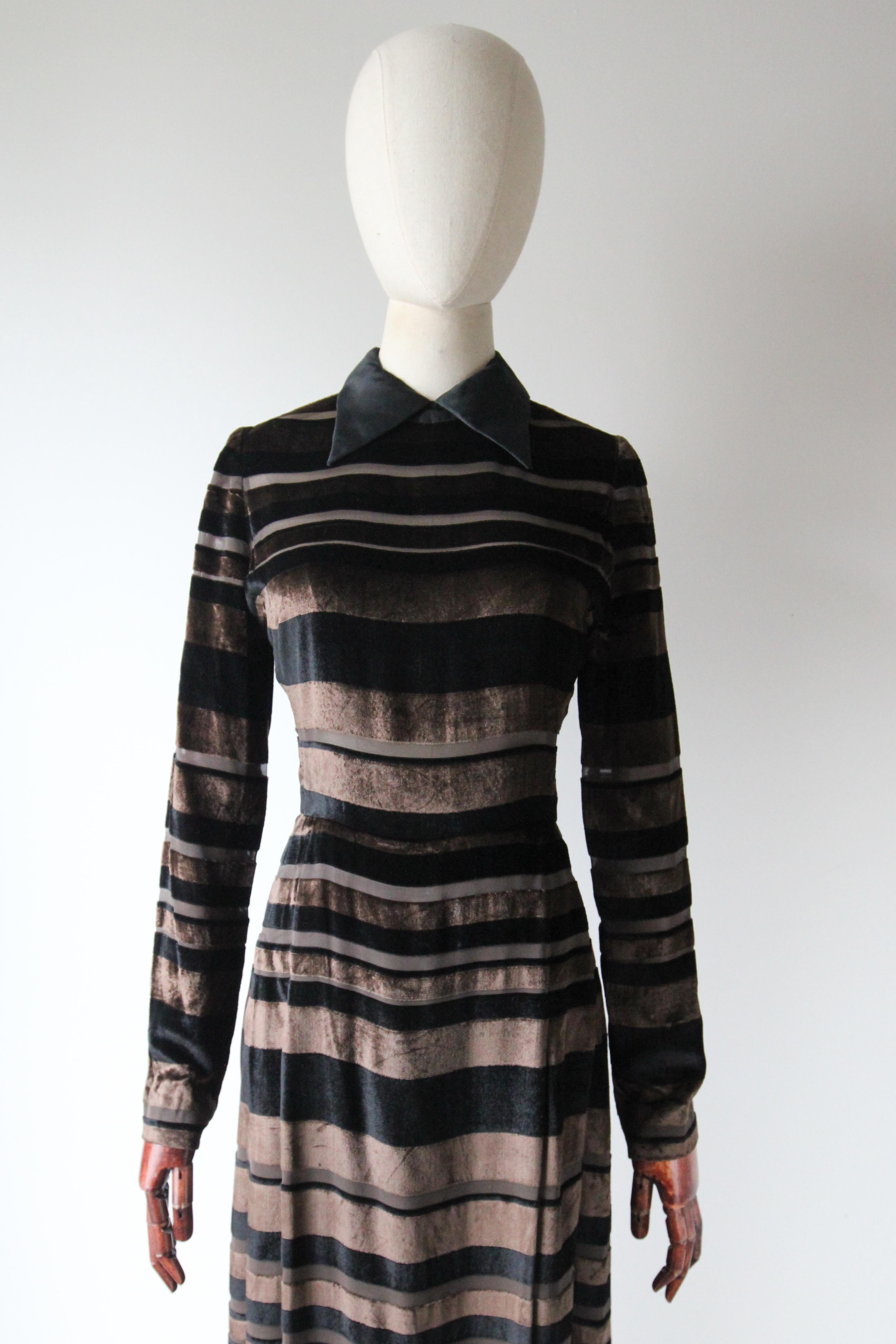 This truly eye-catching 1960's silk evening dress by Nina Ricci, rendered in a striped black and brown silk velvet pattern with brown silk chiffon striped accents is the perfect piece for that special occasion. 

The elegant rounded neckline is