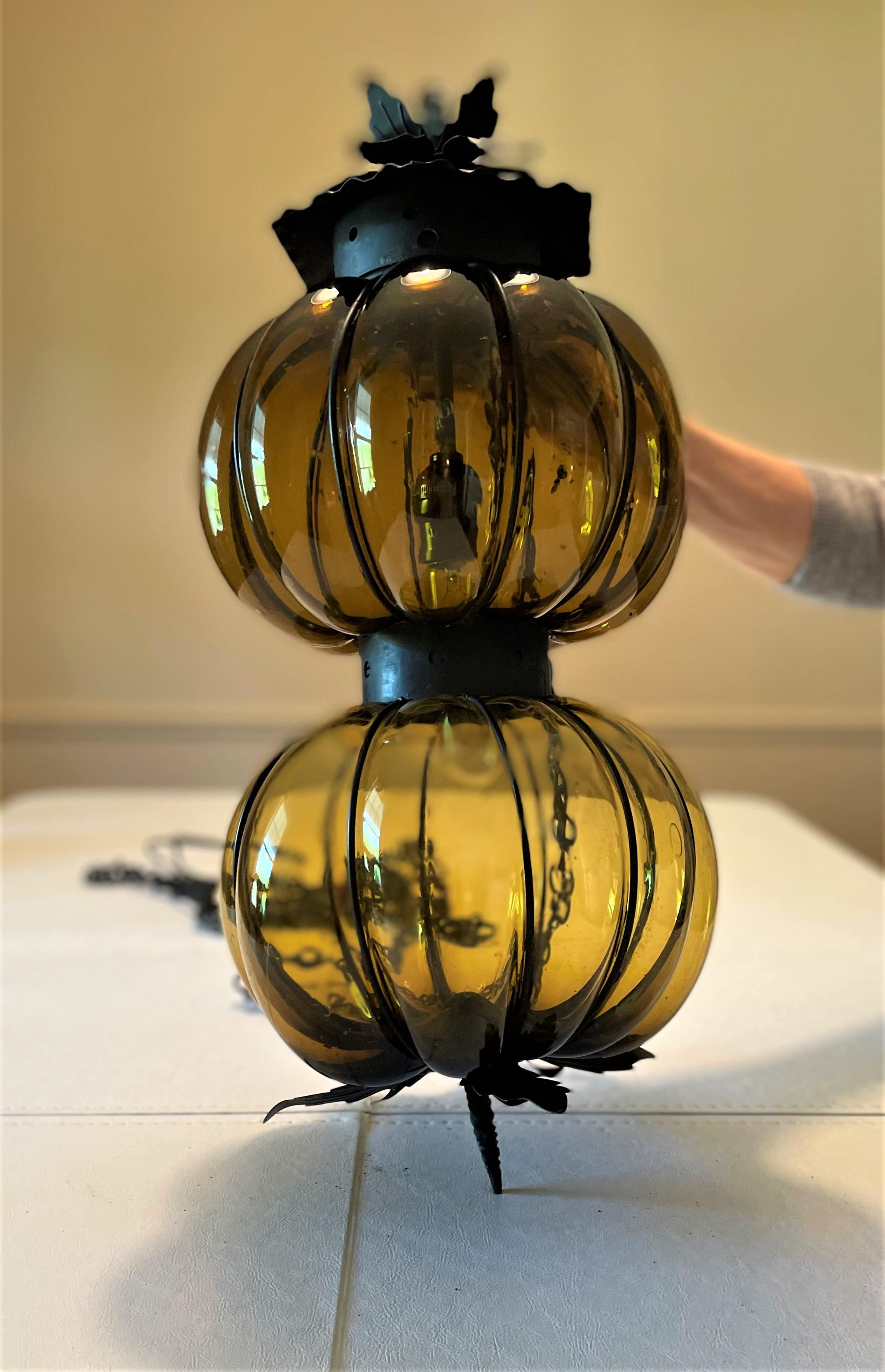 So very 1960s Mod! This large gourd Mexican blown-glass pendant lantern is sized well and has great proportions. It is in mint condition. The olive-green glass casts a moody ambience in the room when lit with a warm bulb. The black chain, intended