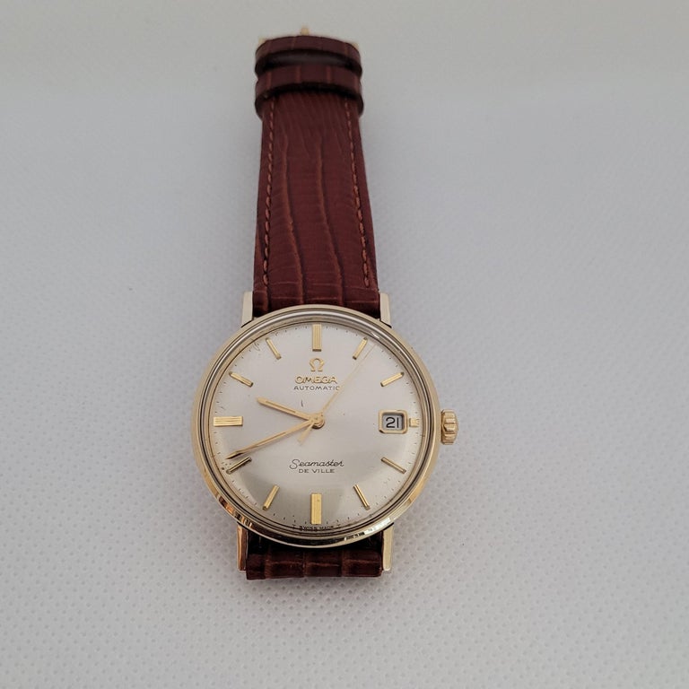 Elegant Vintage 1960's Omega Seamaster Deville Watch that's automatic and has been cleaned and overhauled; comes with a 90-day warranty and fully working condition. The lovely champagne face has a slight feather blemish, date window, with