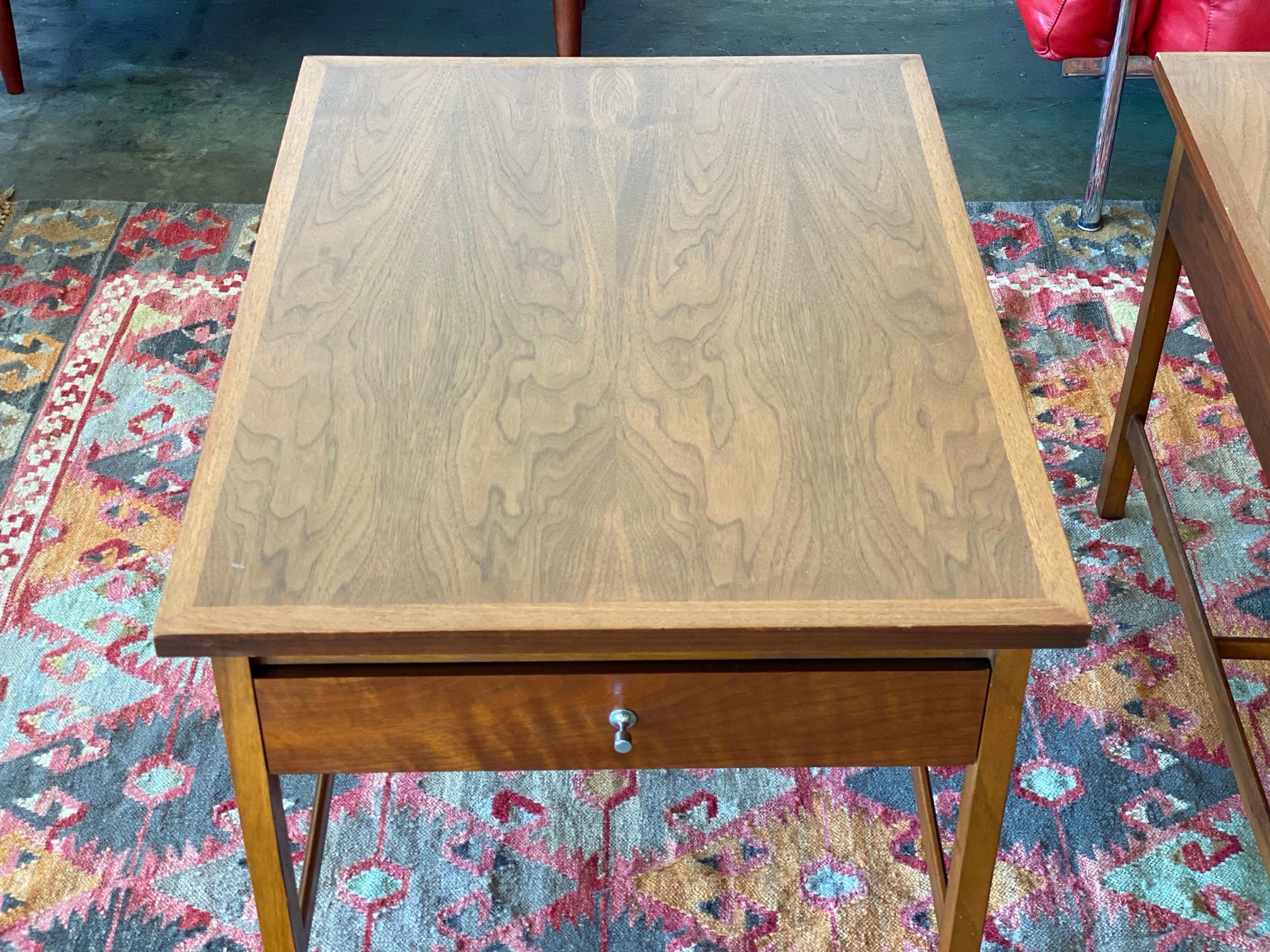 This vintage pair of 'Delineator' walnut side tables by Paul McCobb for Lane are in overall good condition. Each features a single drawer with signature pull. Great as nightstands and end tables. 
circa 1960s. USA.
Dimensions:
30