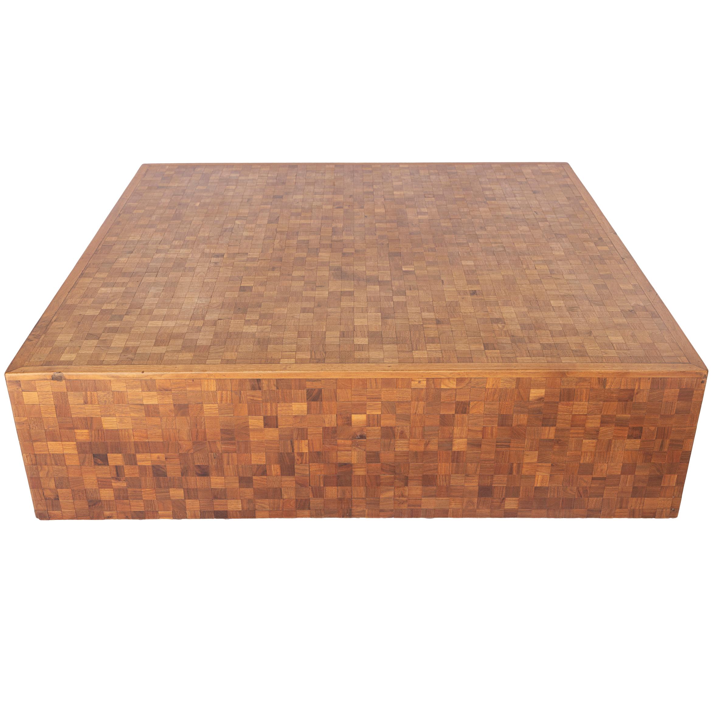 Questo tavolino da caffè Vintage Parquet presenta una finitura in parquet e una base a piedistallo. Si tratta di un tavolino d'epoca imponente e sostanzioso, con una struttura in blocchi di legno montati artigianalmente, ideale per le sedute di casa