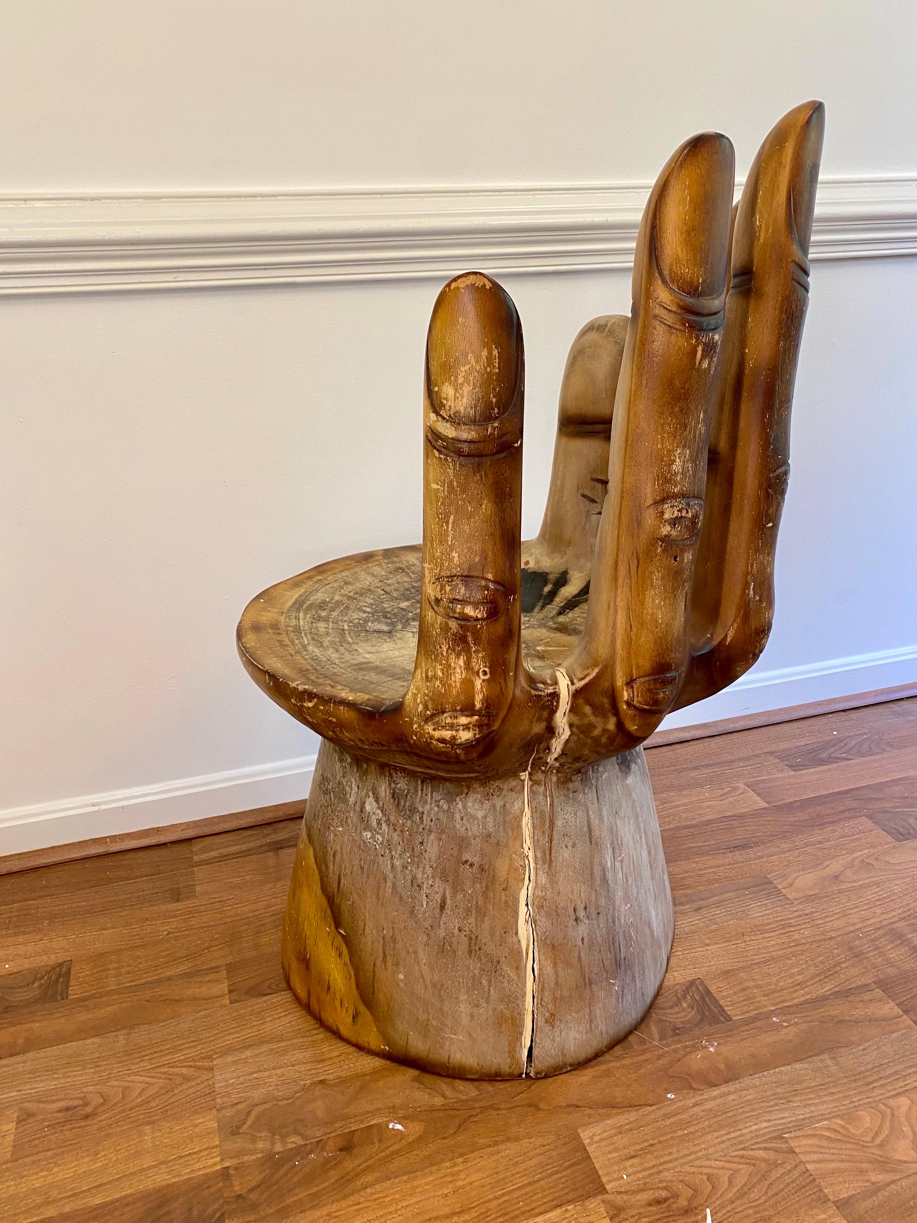 Beautiful wood hand motif sculpture chair made from a single stump. A true work of stunning craftsmanship, the attention to detail on the fingers and base of this remarkable, one-of-a-kind piece prove it was made with love. Heavy, sturdy and stable—