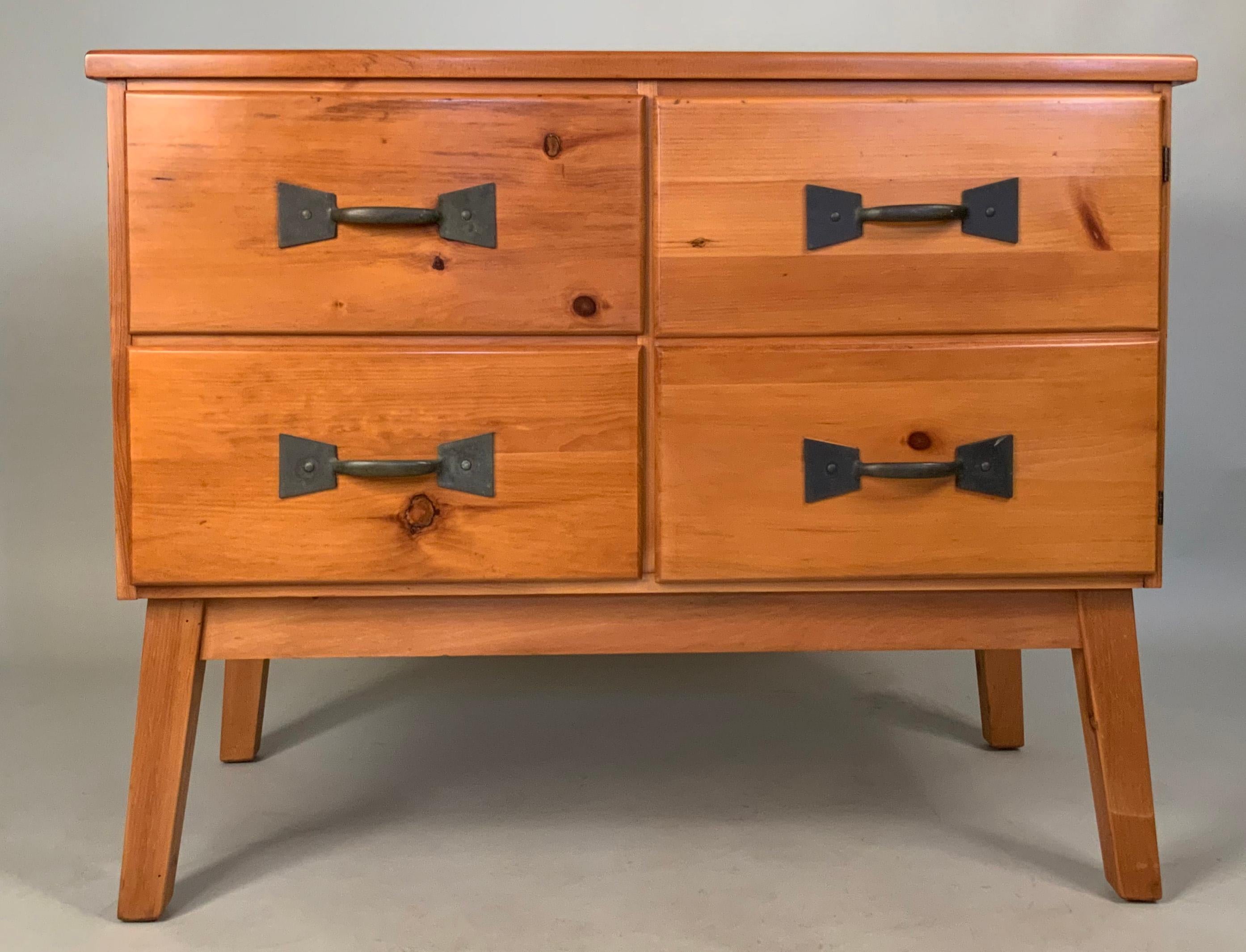 A very charming vintage 1960s pine chest/cabinet by Habitant, raised on pine legs, with patinated brass hardware. The left side of the case has a pair of drawers, and the right side has a hinged door made to look like another pair of drawers. The