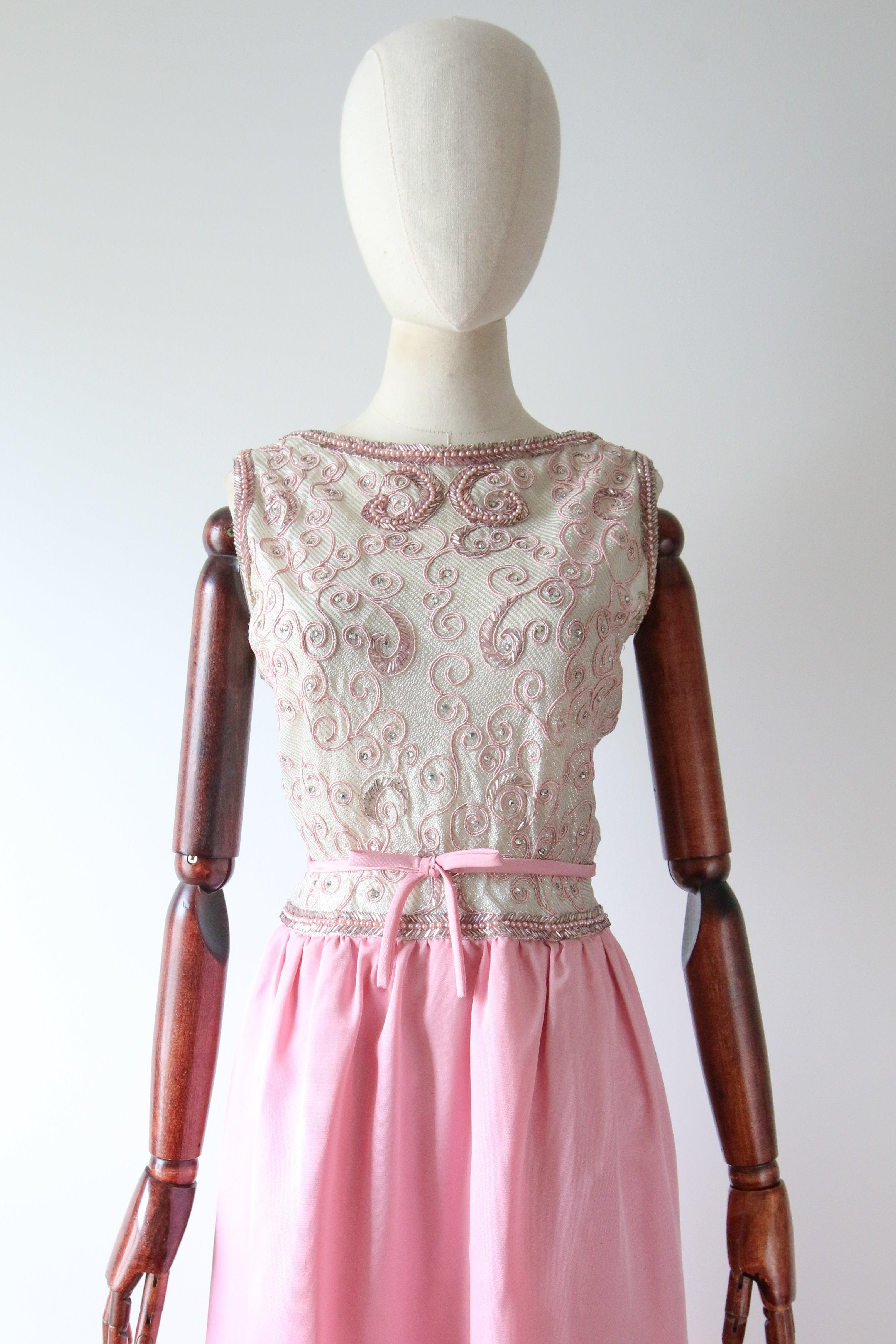 This show stopping original 1960's evening gown, rendered in a silver striped lurex fabric, which is in turn embellished with pink trailing soutache embroidery, claw set rhinestones and pink beadwork, and contrasted with a ballerina pink faille, is