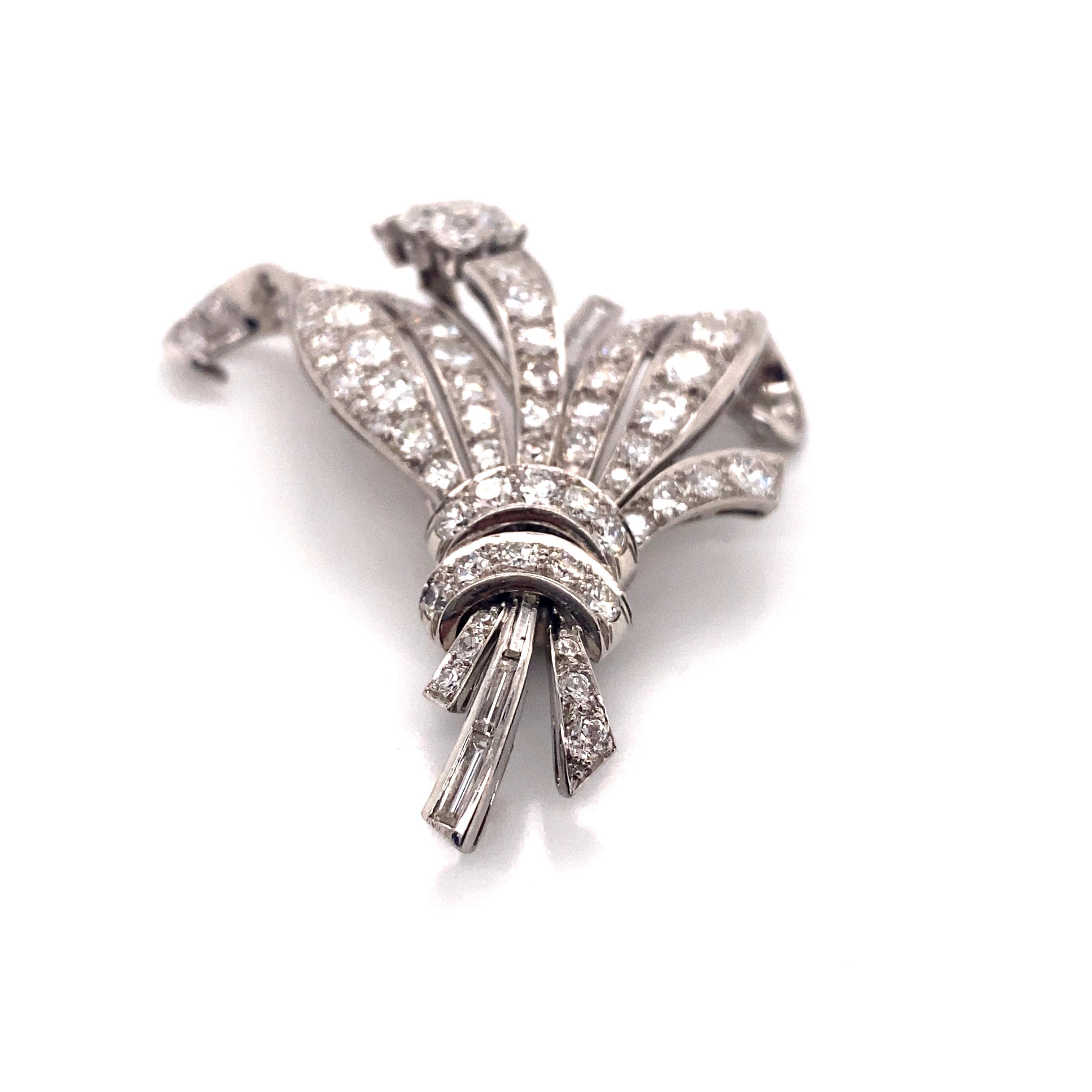 This exquisite brooch is a stunning example of 1960s jewelry craftsmanship. Crafted in luxurious platinum, it features an ornate bouquet design encrusted with 87 round brilliant diamonds totaling an impressive 5.79 carats. The diamonds exhibit a