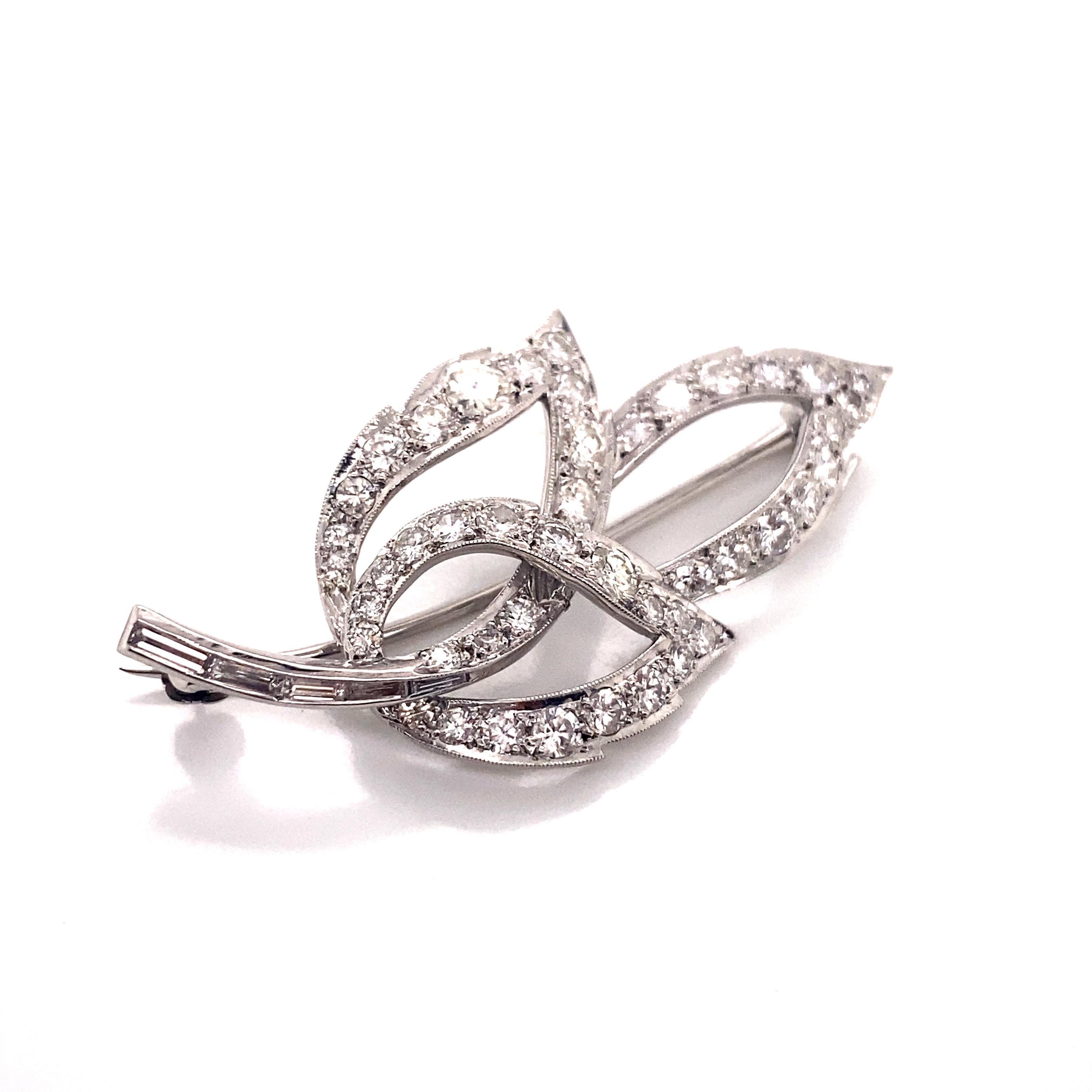 This exquisite vintage pin from the 1960s is a breathtaking representation of nature's beauty, rendered in lustrous platinum and dazzling diamonds. Crafted with meticulous attention to detail, it takes the form of an elegant leaf, a timeless symbol
